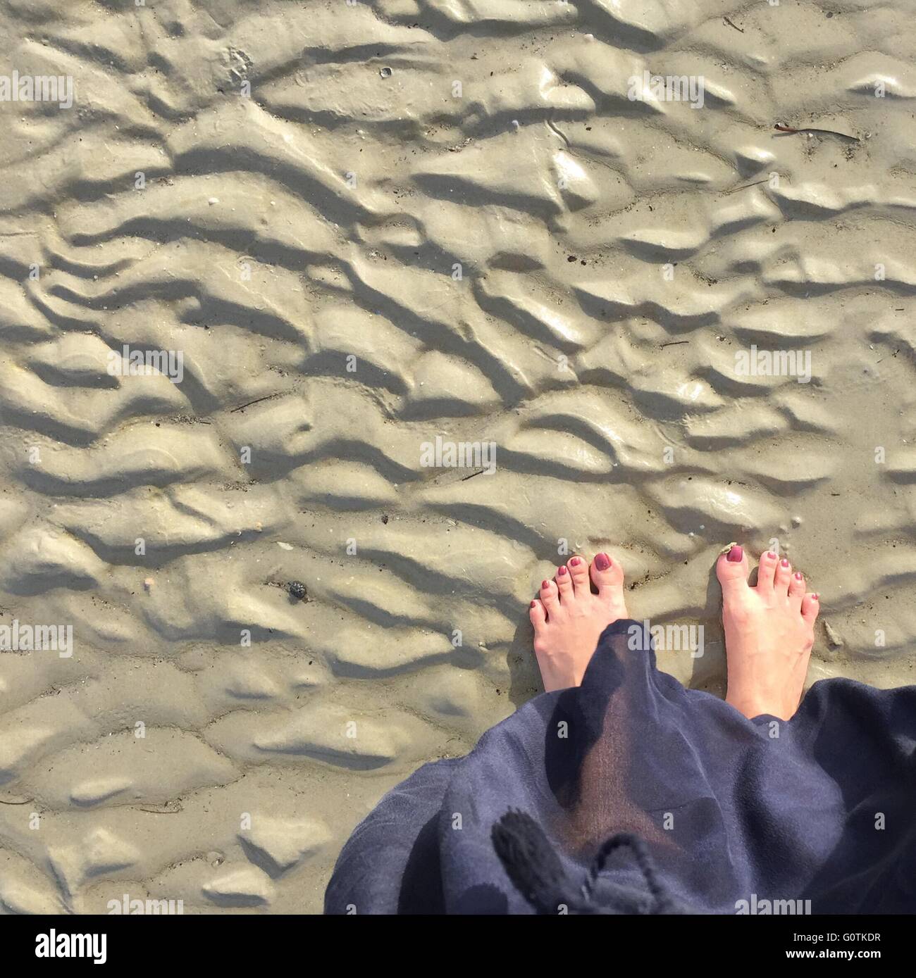 Overhead view of feet on beach Stock Photo