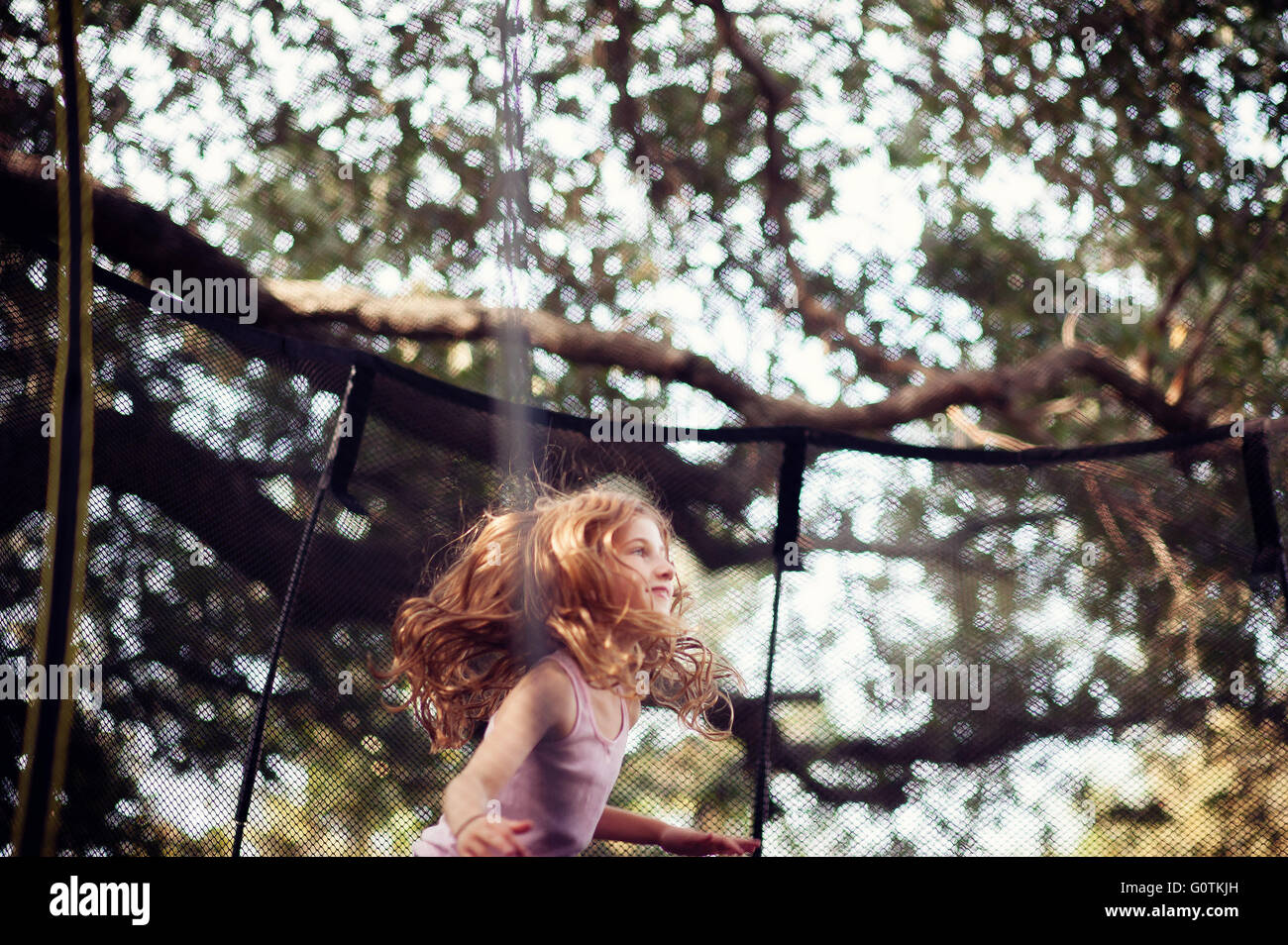 girl jumping on trampoline Stock Photo