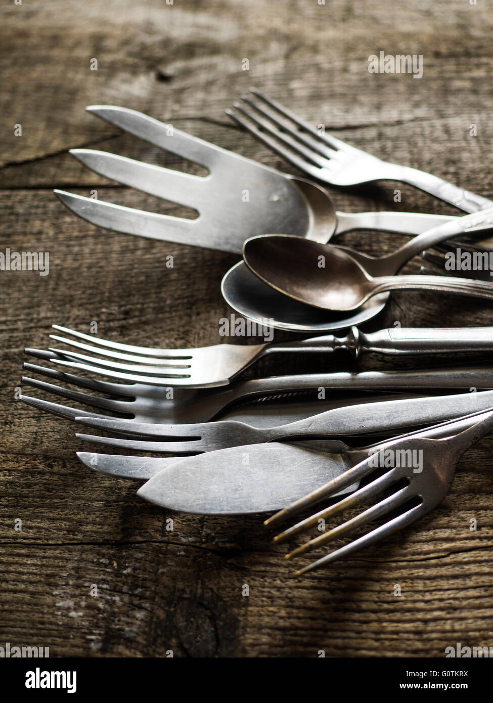 Stack of old vintage cutlery on wooden table Stock Photo