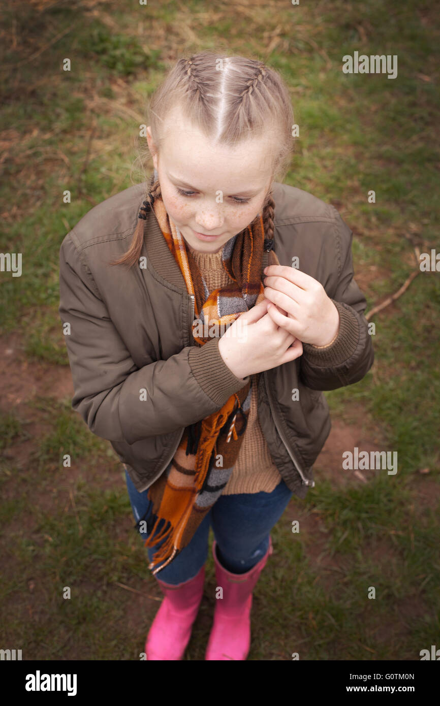 Pretty young girl with freckles playing with her braids Stock Photo