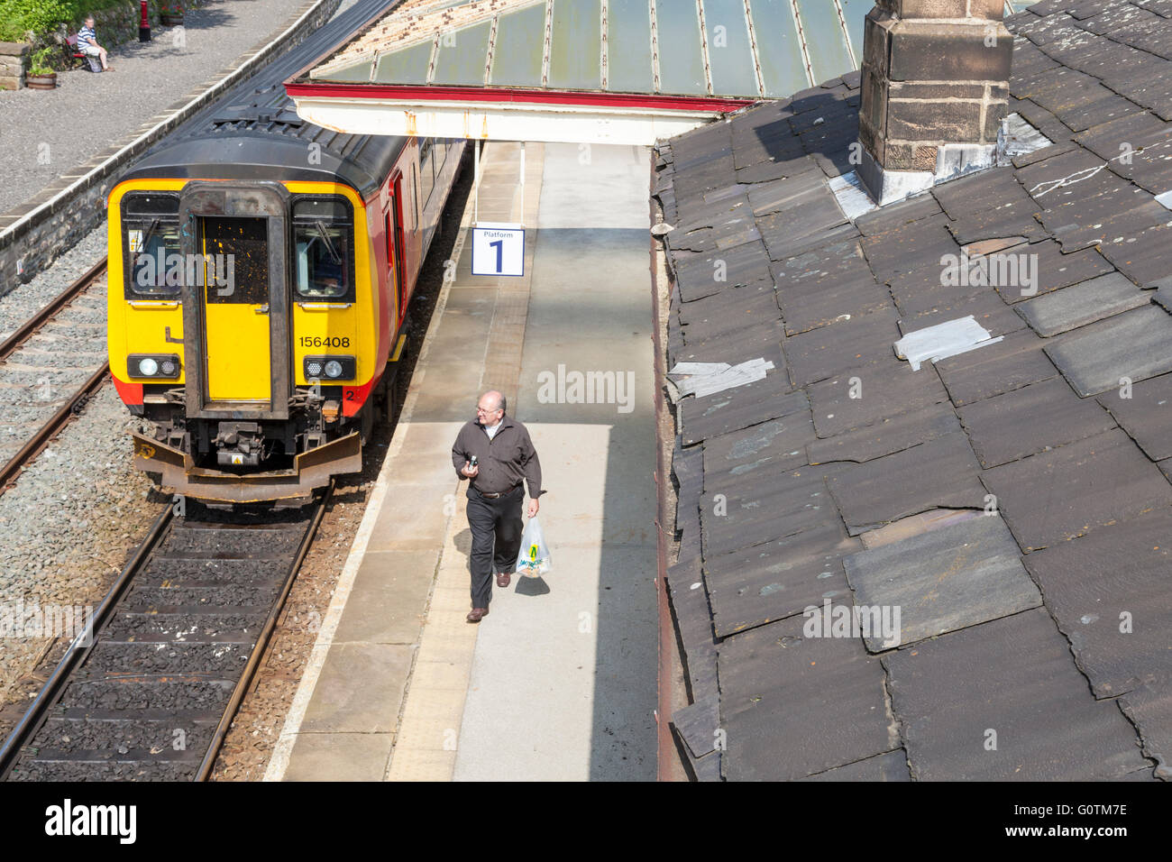 Person leaving a train walking along a platform at Matlock Railway Station, Derbyshire, England, UK Stock Photo