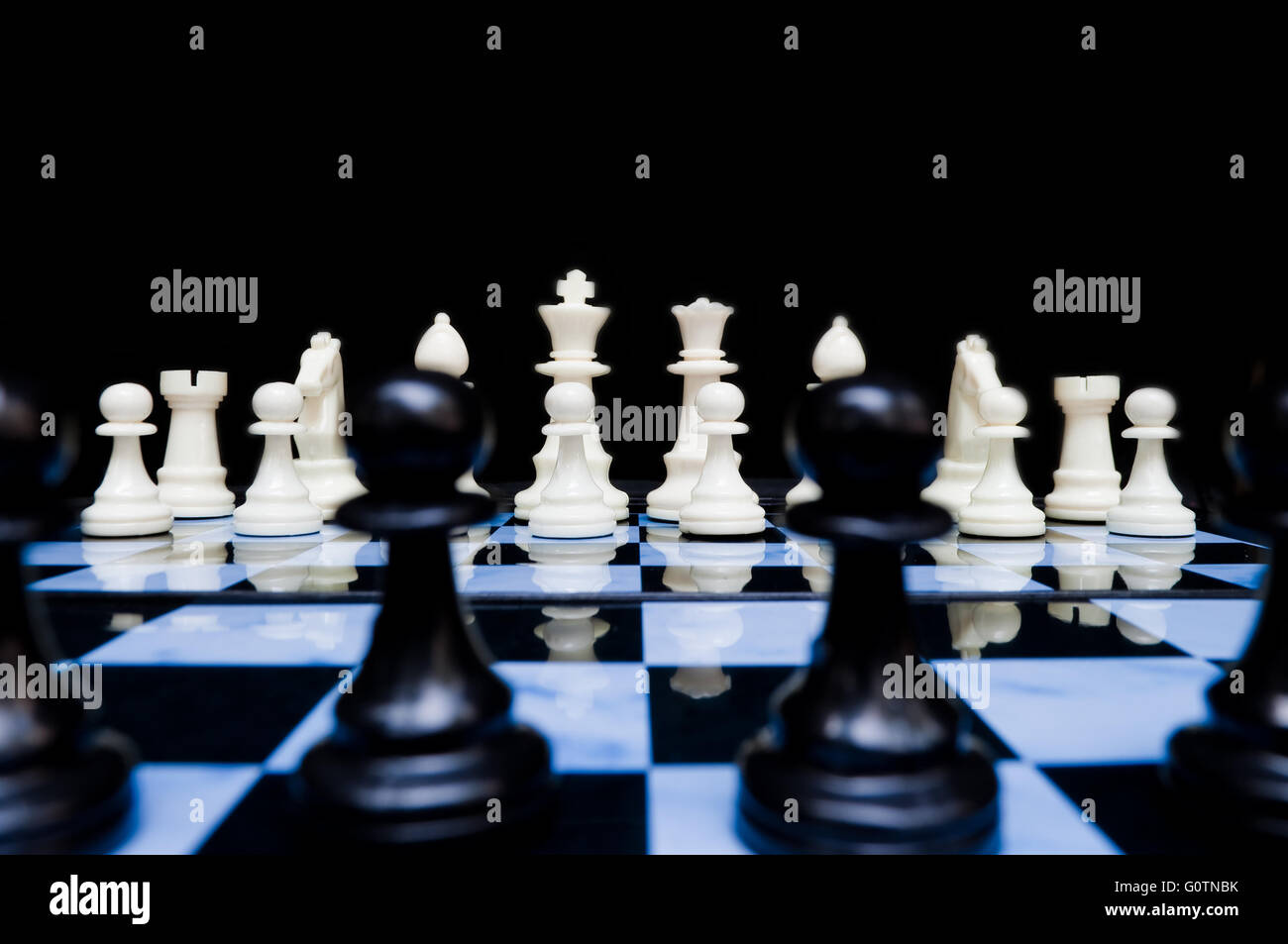 White chess pieces in set up position viewed from back line of black