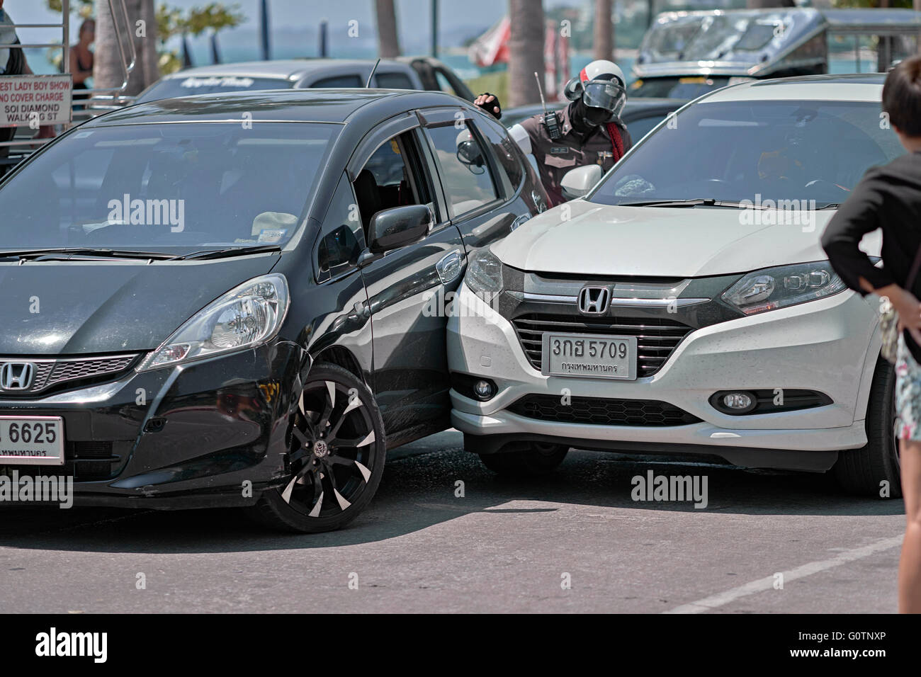 Thailand  police officer attending a road accident involving the collision of two vehicles. Thailand S. E. Asia Stock Photo