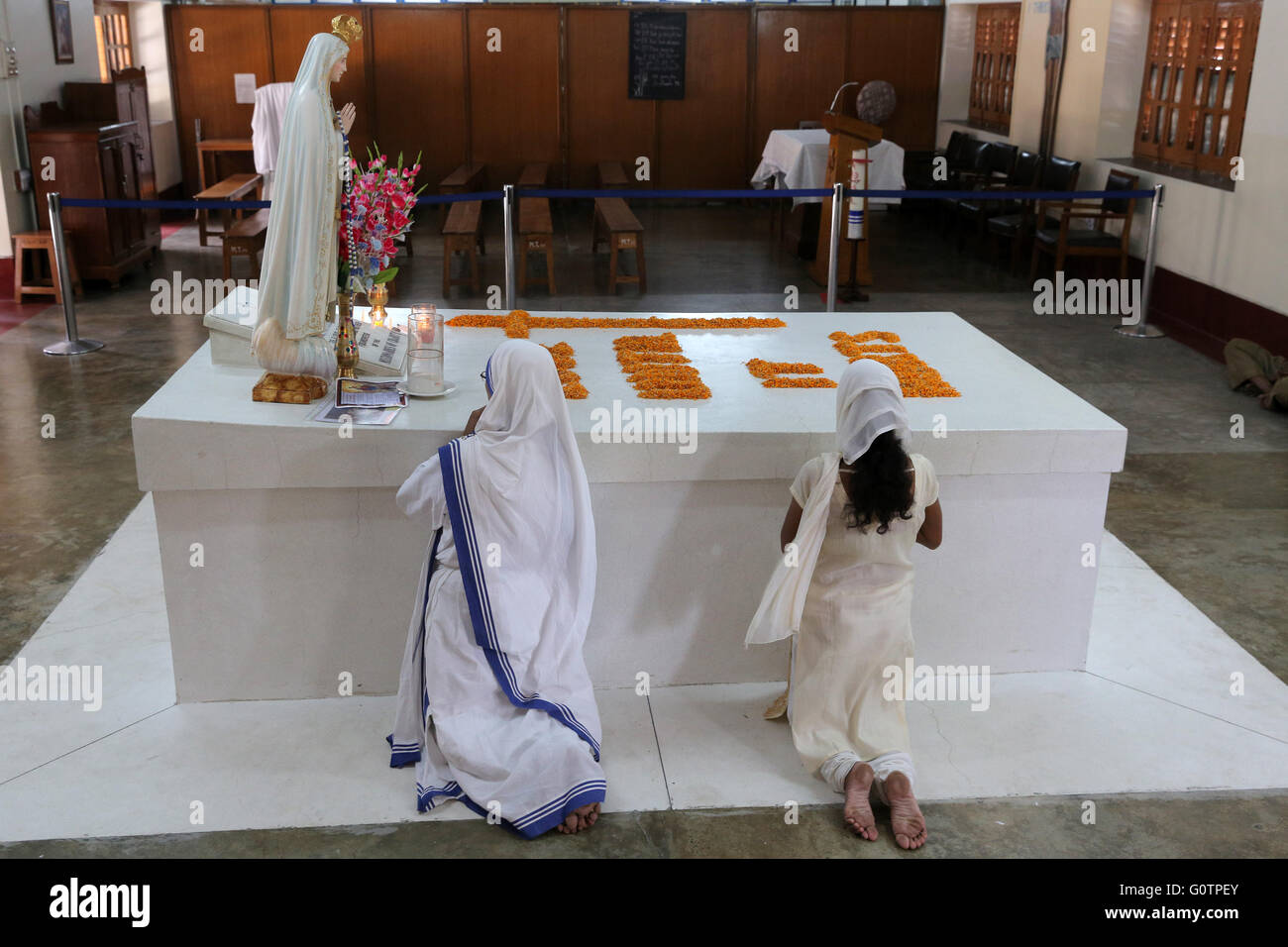 Nuns praying at the tomb of Mother Teresa at the Mother´s House of the Missionaries of Charity (Mother Teresa sisters) in Kolkata, Calcutta, India Stock Photo
