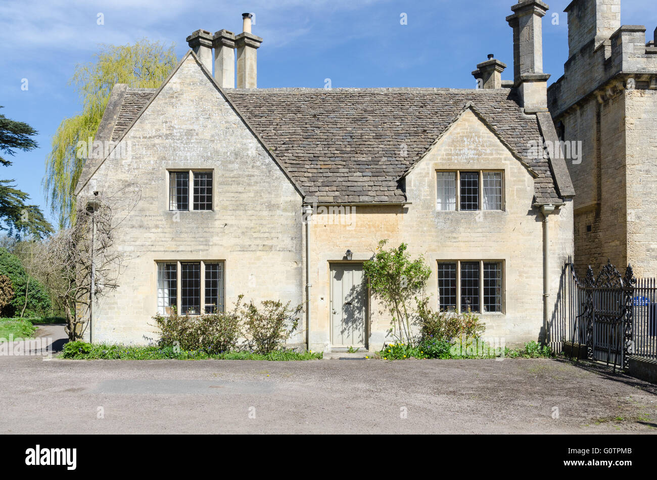 Typical Cotswold stone house at the entrance to Cirencester Park on the Bathurst estate in Cirencester Stock Photo