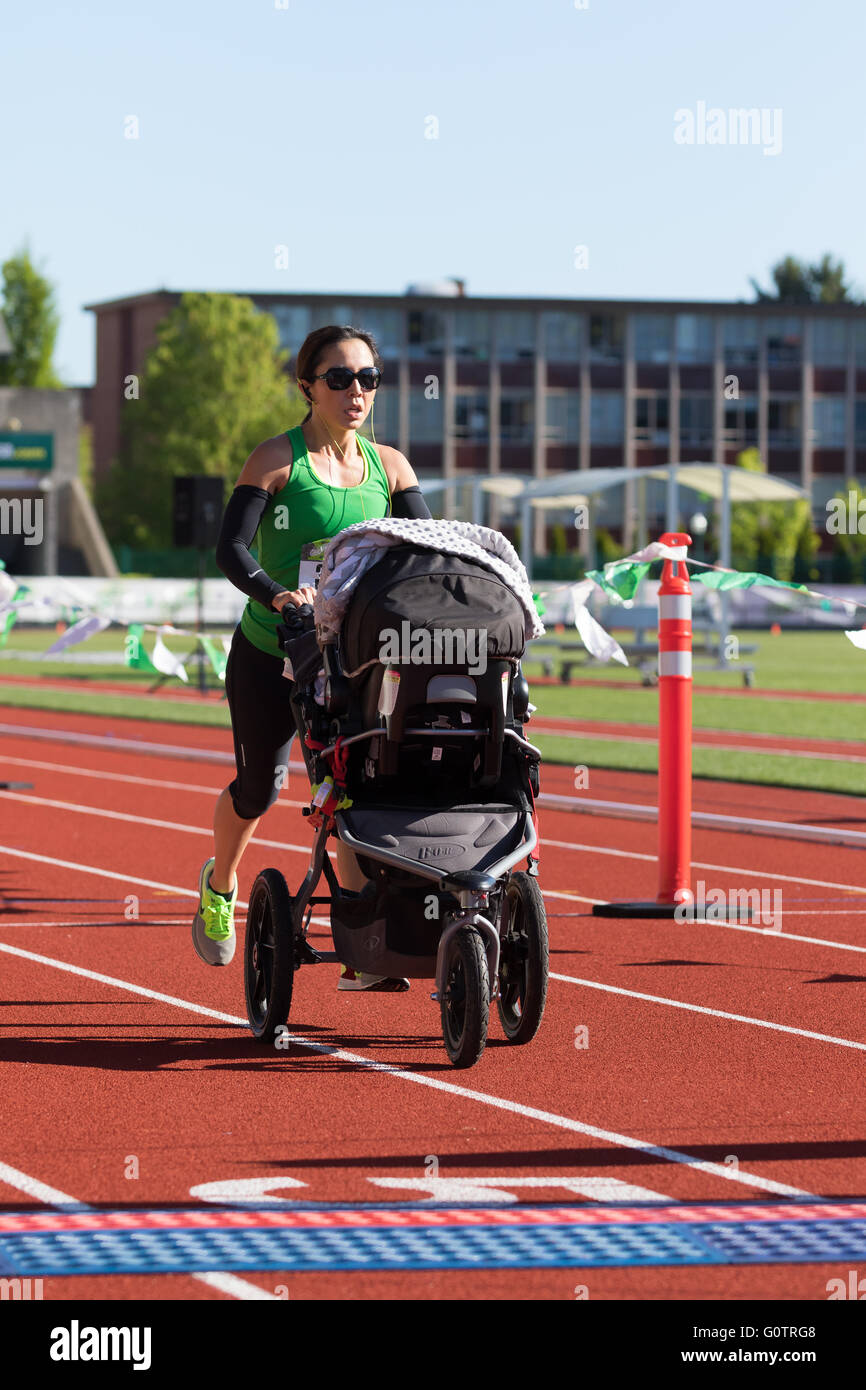 EUGENE, OR - MAY 1, 2016: Mom with a BOB running stroller on the track finishing the 2016 Eugene Marathon, a Boston qualifying e Stock Photo