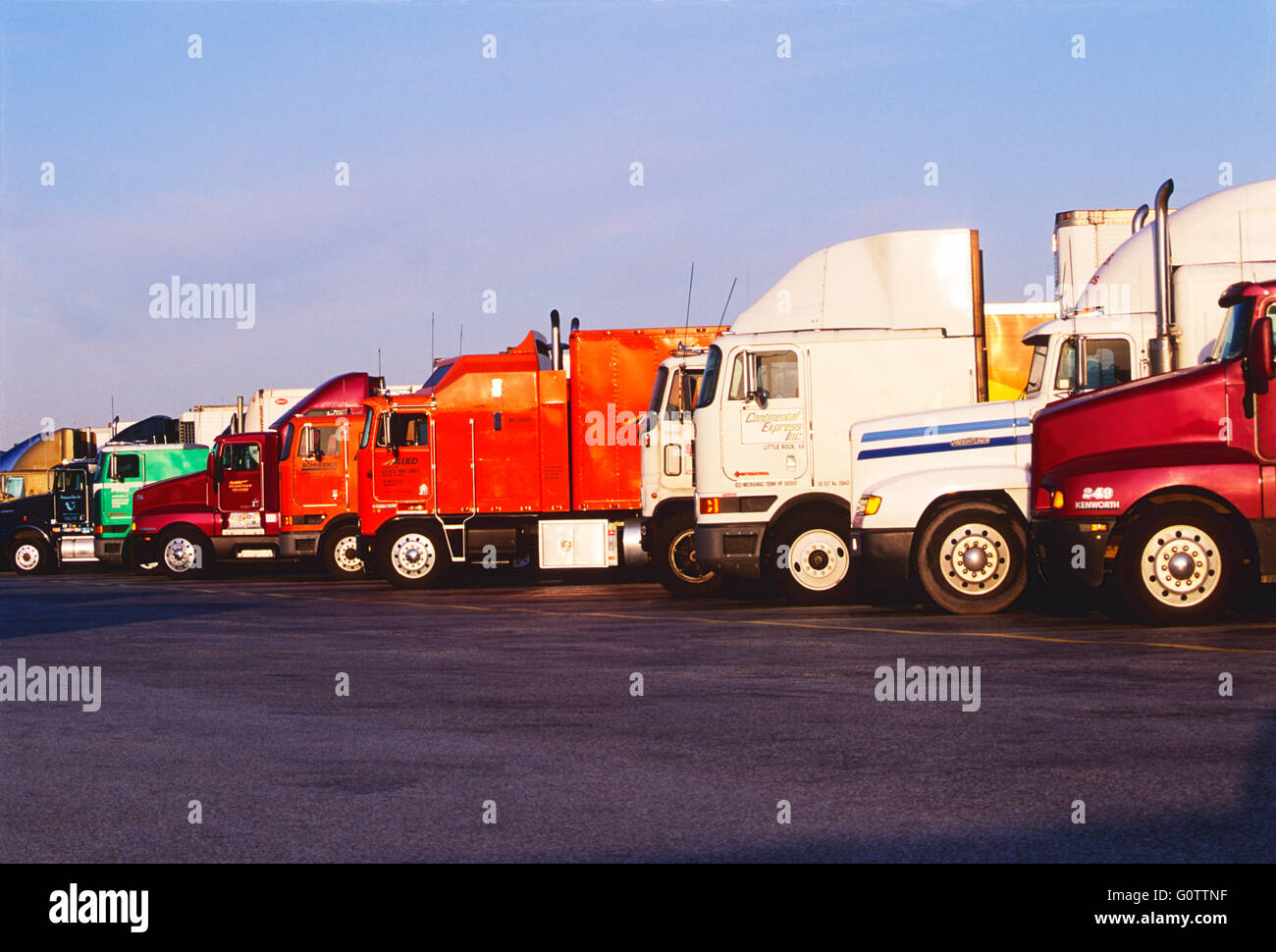 Parked tractor trailer trucks lined up at truck stop rest area Stock Photo