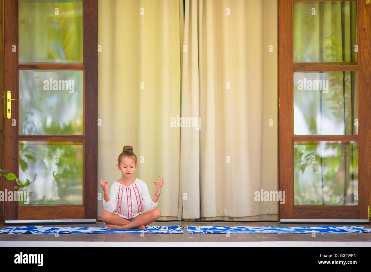 Little girl doing yoga exercise on terrace outdoors Stock Photo - Alamy