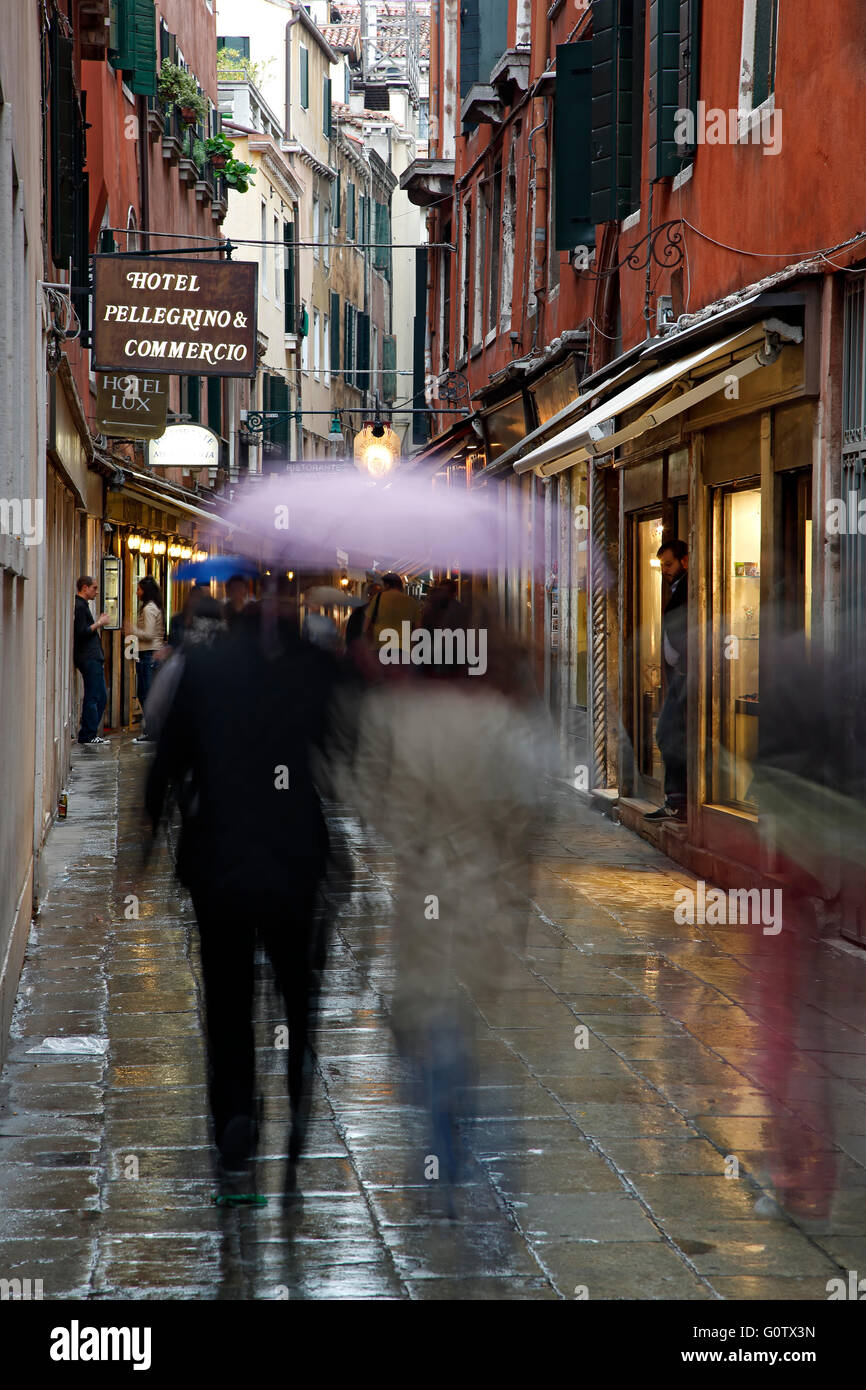 People with umbrellas on wet street, Venice, Italy Stock Photo