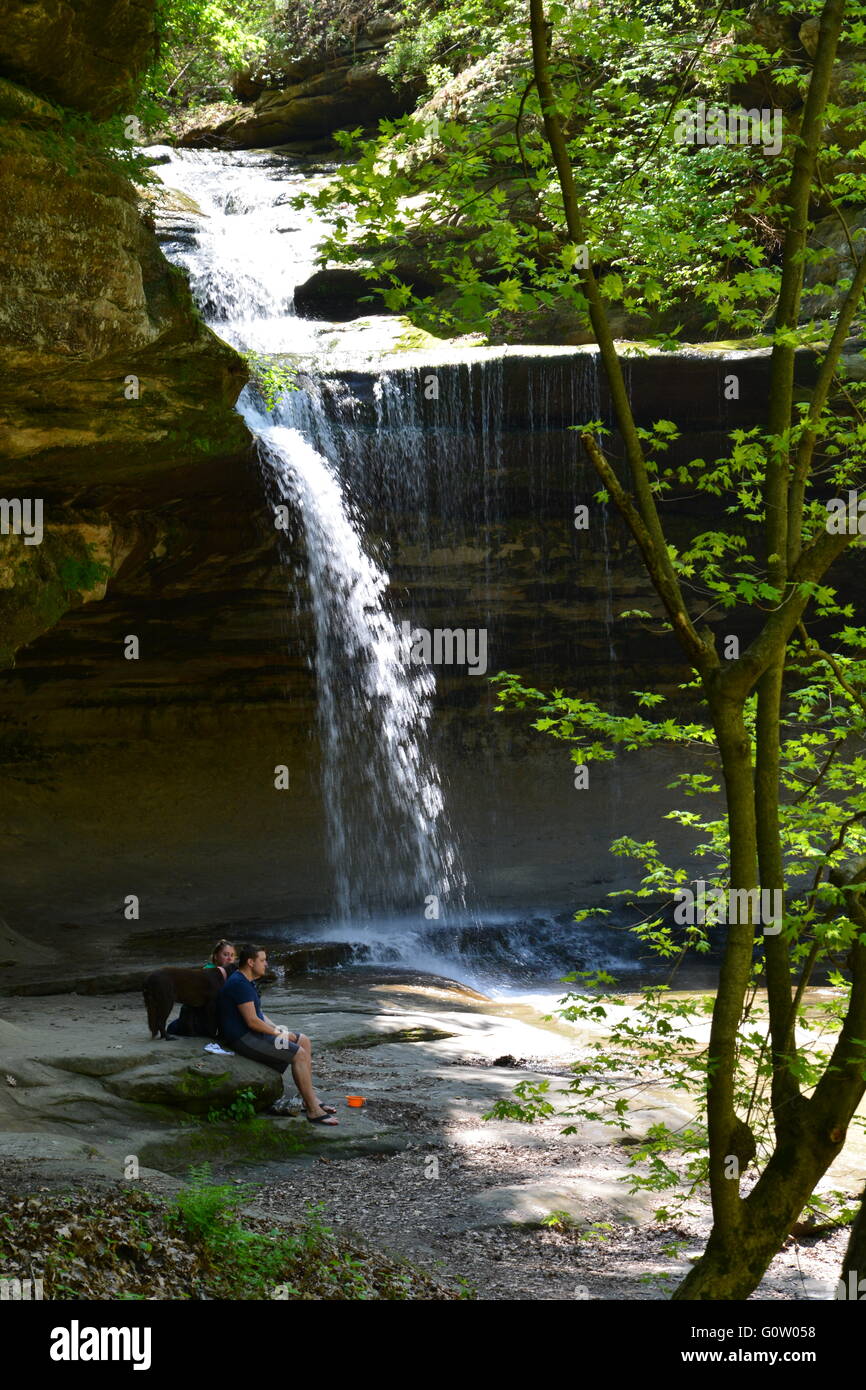 Hikers with a dog resting at the waterfall in La Salle Canyon at Starved Rock State Park on the banks of the Illinois River. Stock Photo