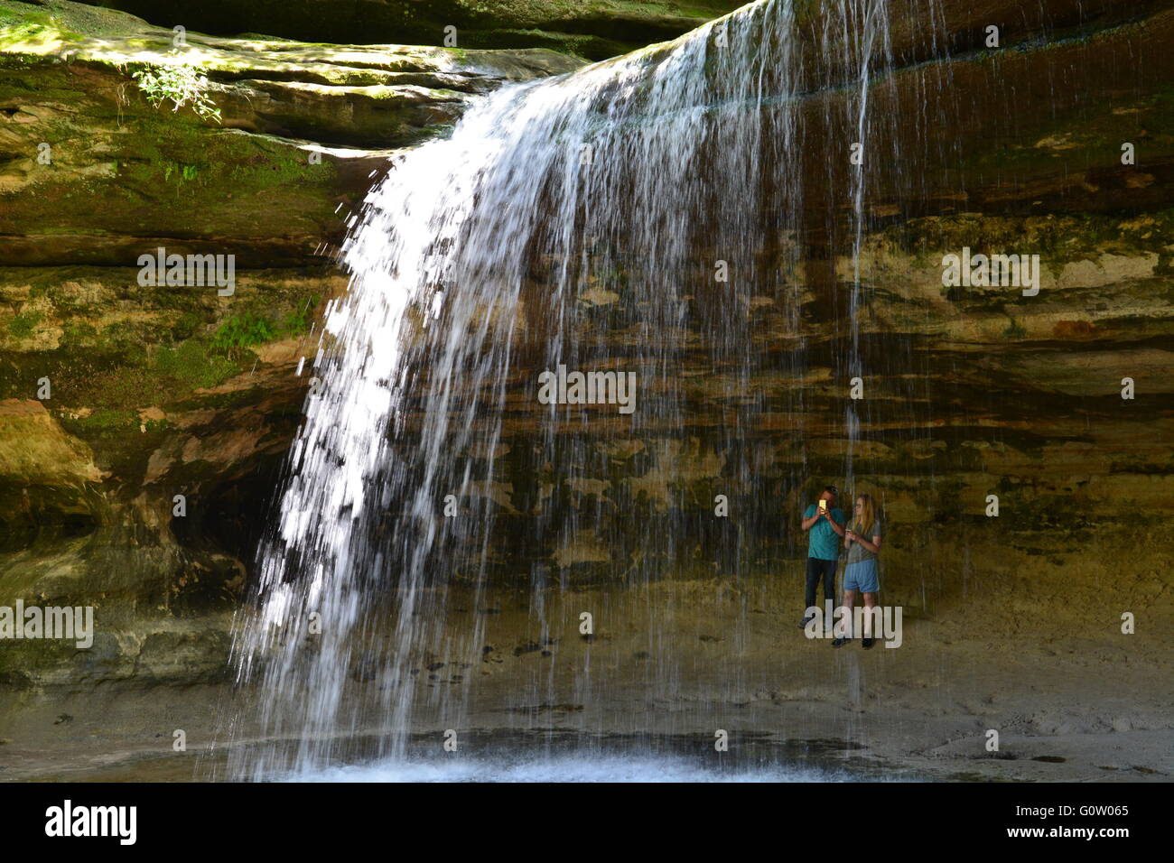 Hikers at the sandstone cliff waterfall in La Salle Canyon at Starved Rock State Park on the banks of the Illinois River. Stock Photo