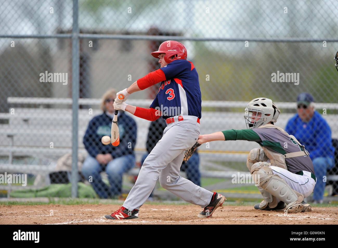 A hitter follows through on his swing while making contact with a pitch