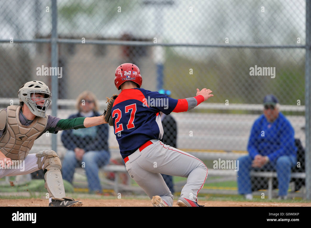 While trying to score, a high school player is tagged out by the opposing catcher. USA. Stock Photo