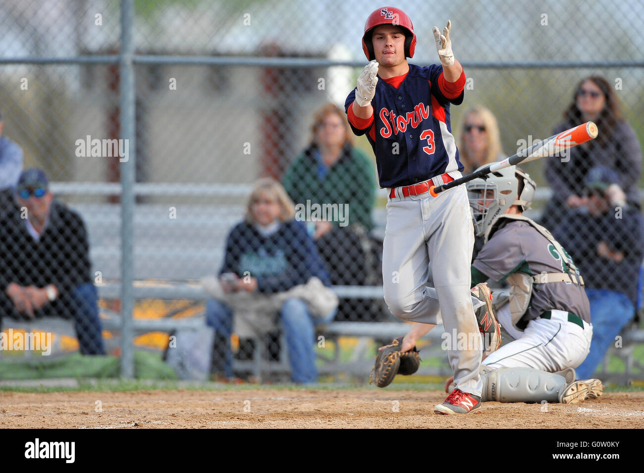 Player tossing his bat aside after drawing a bases-loaded walk to force in the winning run to end a high school baseball game. USA. Stock Photo