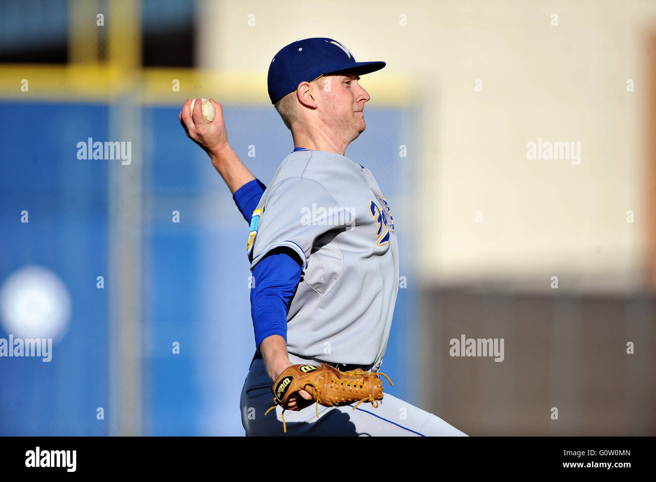 Lefthanded pitcher delivering a pitch to a waiting hitter during a