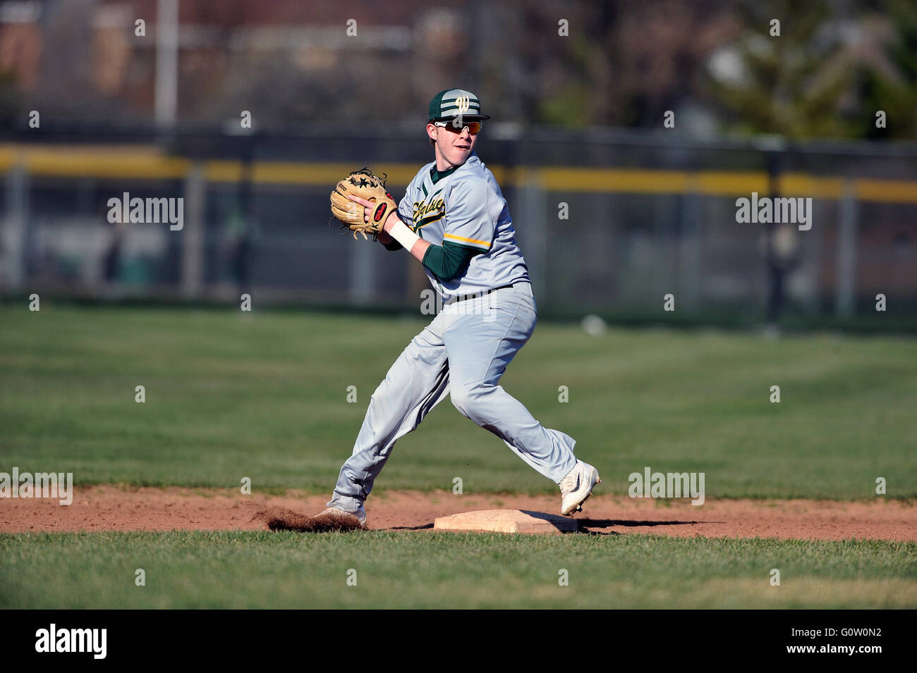 High school second baseman at second base accepting a throw before making a relay on a double-play attempt. Stock Photo