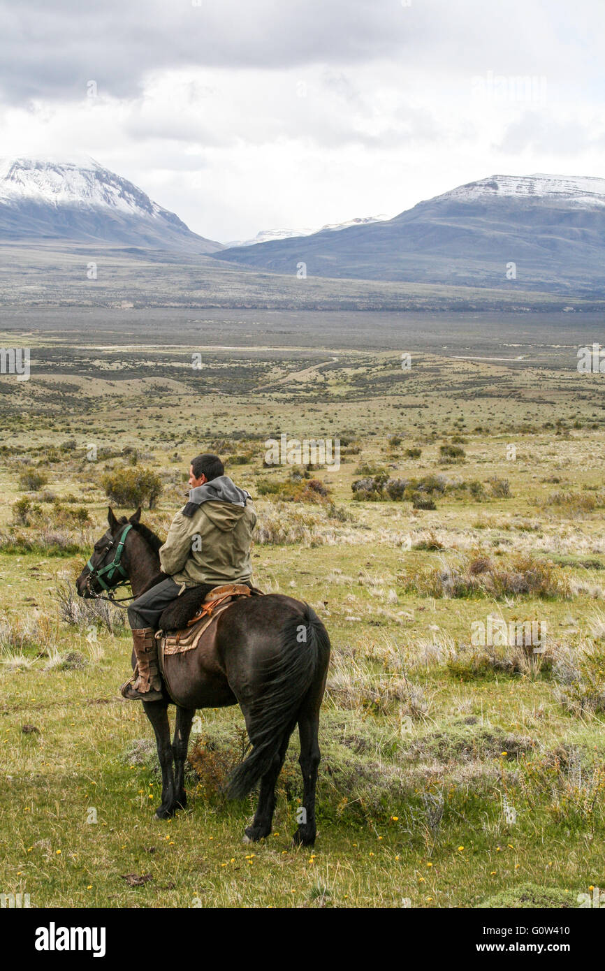 Goucho on his horse, looking towards distant mountains, Patagonia Stock Photo