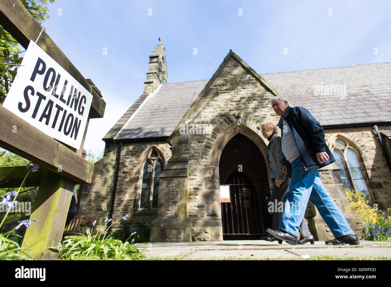 Formby, Merseyside. 5 May 2016. Two members of the public pass St Luke's Church, in Formby, as they make their way to a nearby polling station, to cast their votes in local elections, on 5 May 2016. Credit:  Harry Whitehead/Alamy Live News Stock Photo