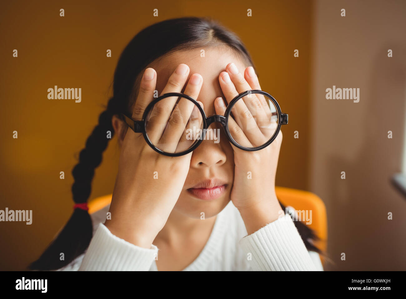 Schoolchild hiding her eyes Stock Photo