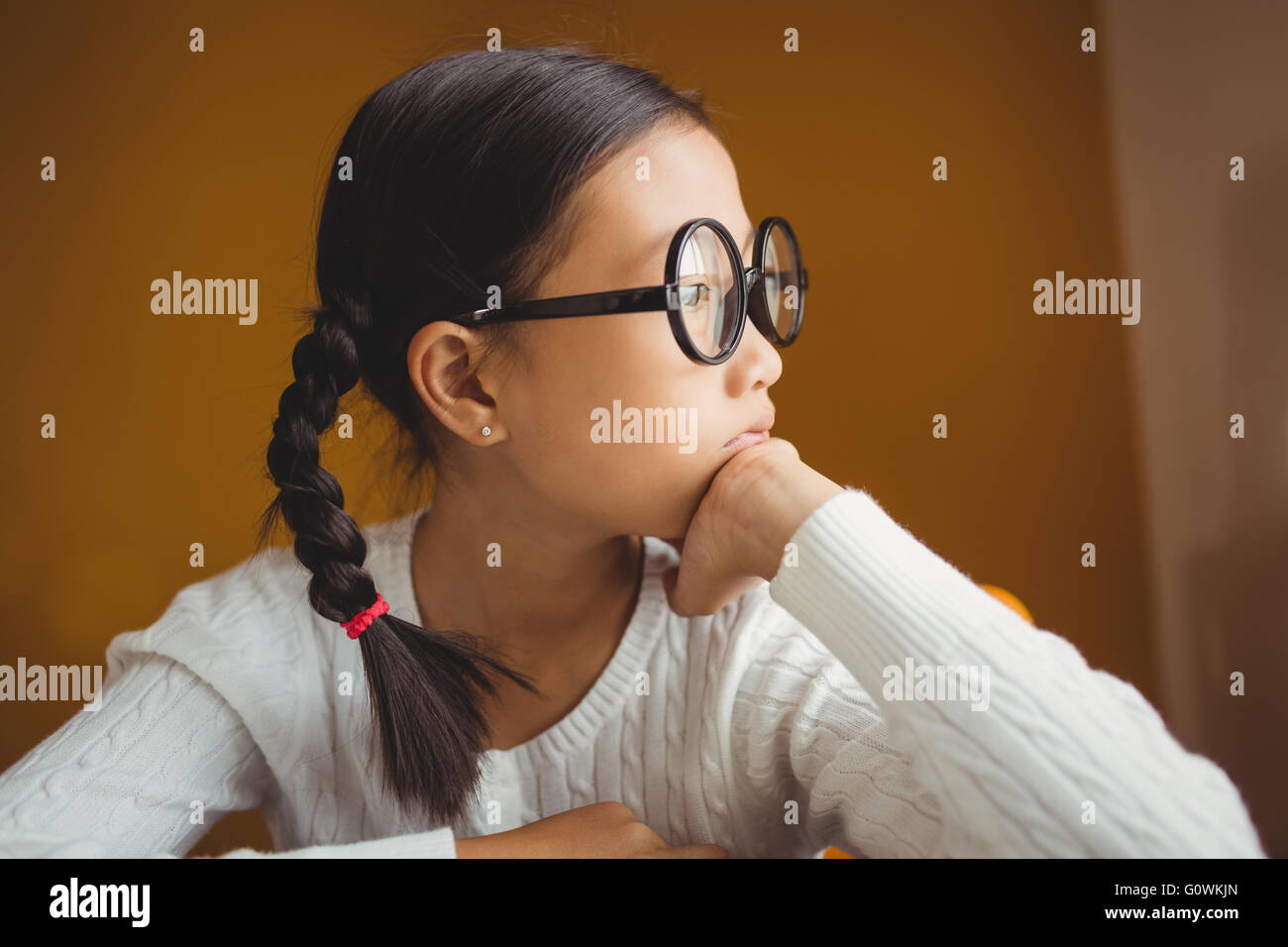Schoolchild touching her chin Stock Photo