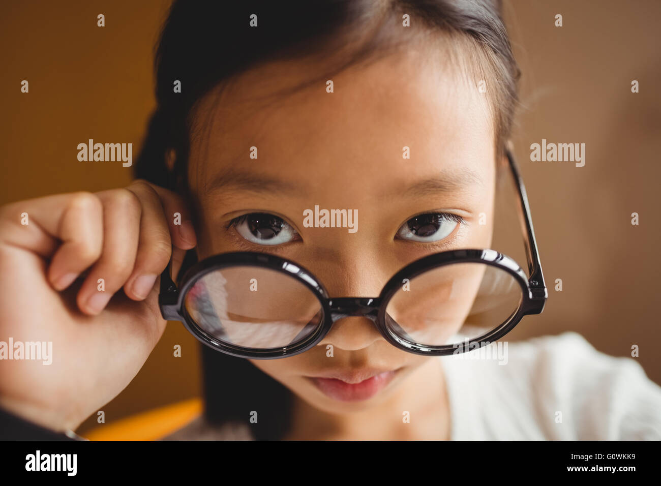 Schoolchild holding her glasses Stock Photo