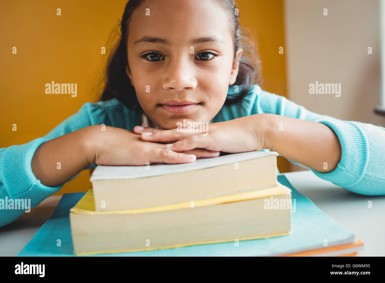 Girl leaning her head on pile of books Stock Photo - Alamy