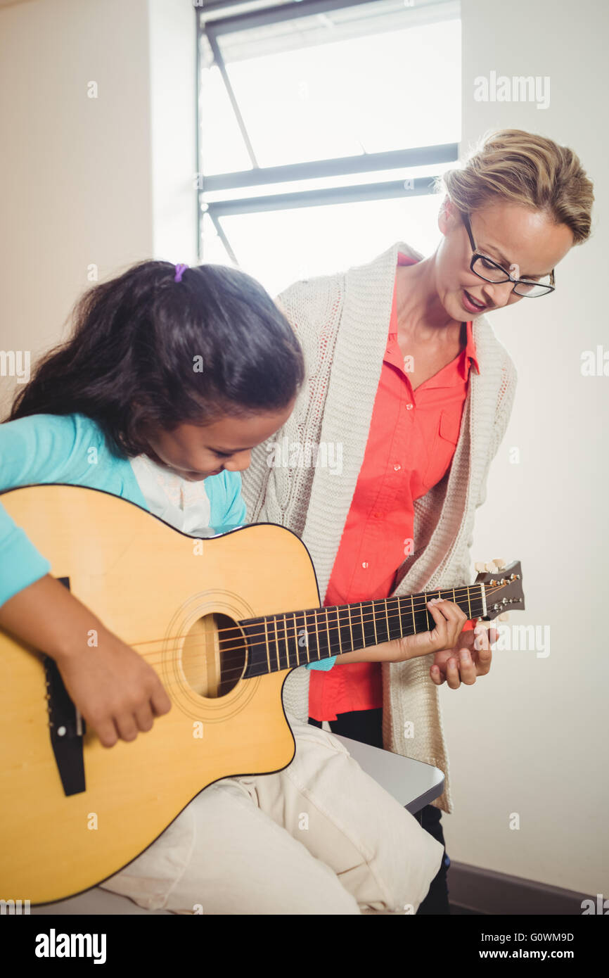 Girl learning how to play the guitar Stock Photo