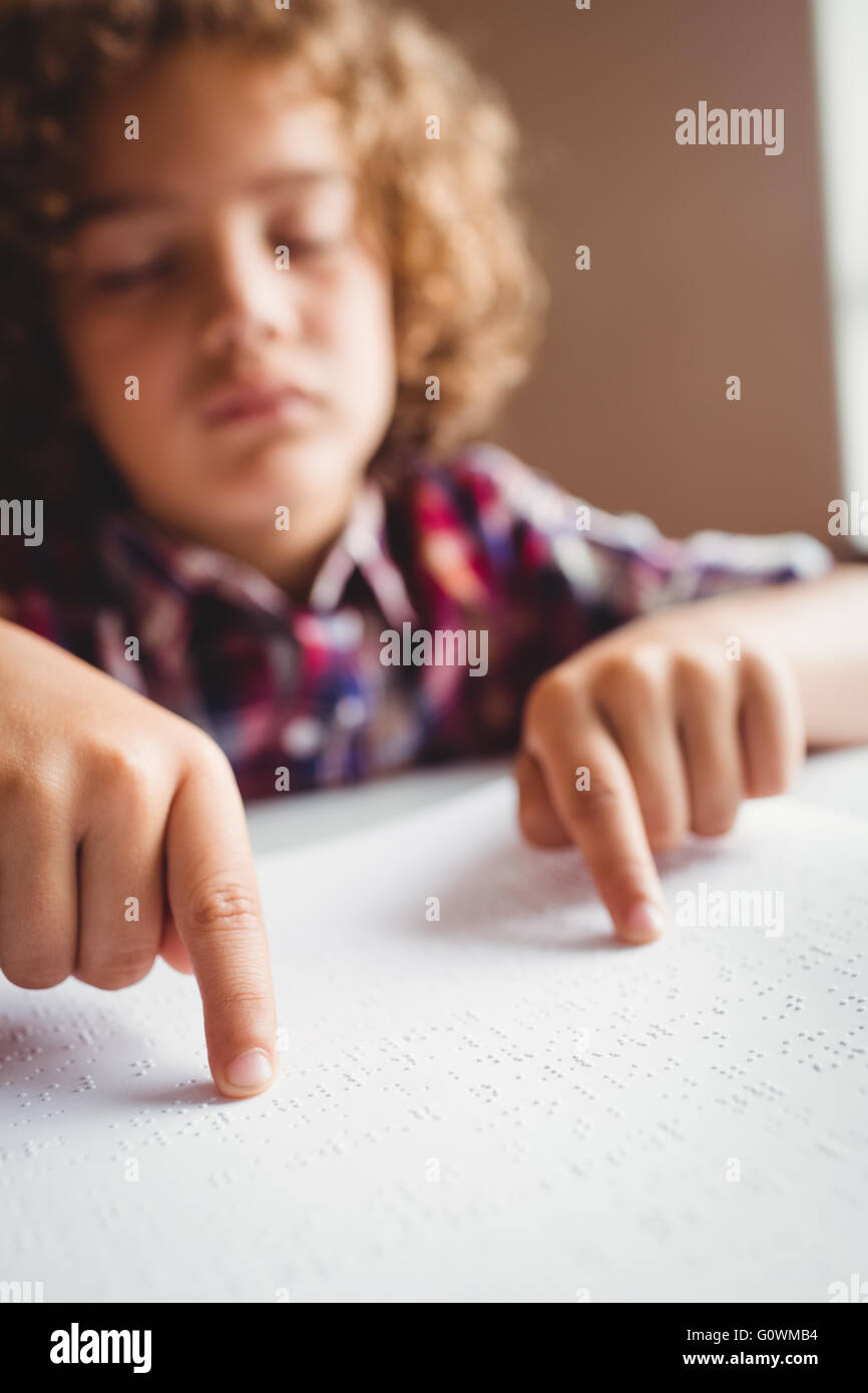 Boy using braille to read Stock Photo