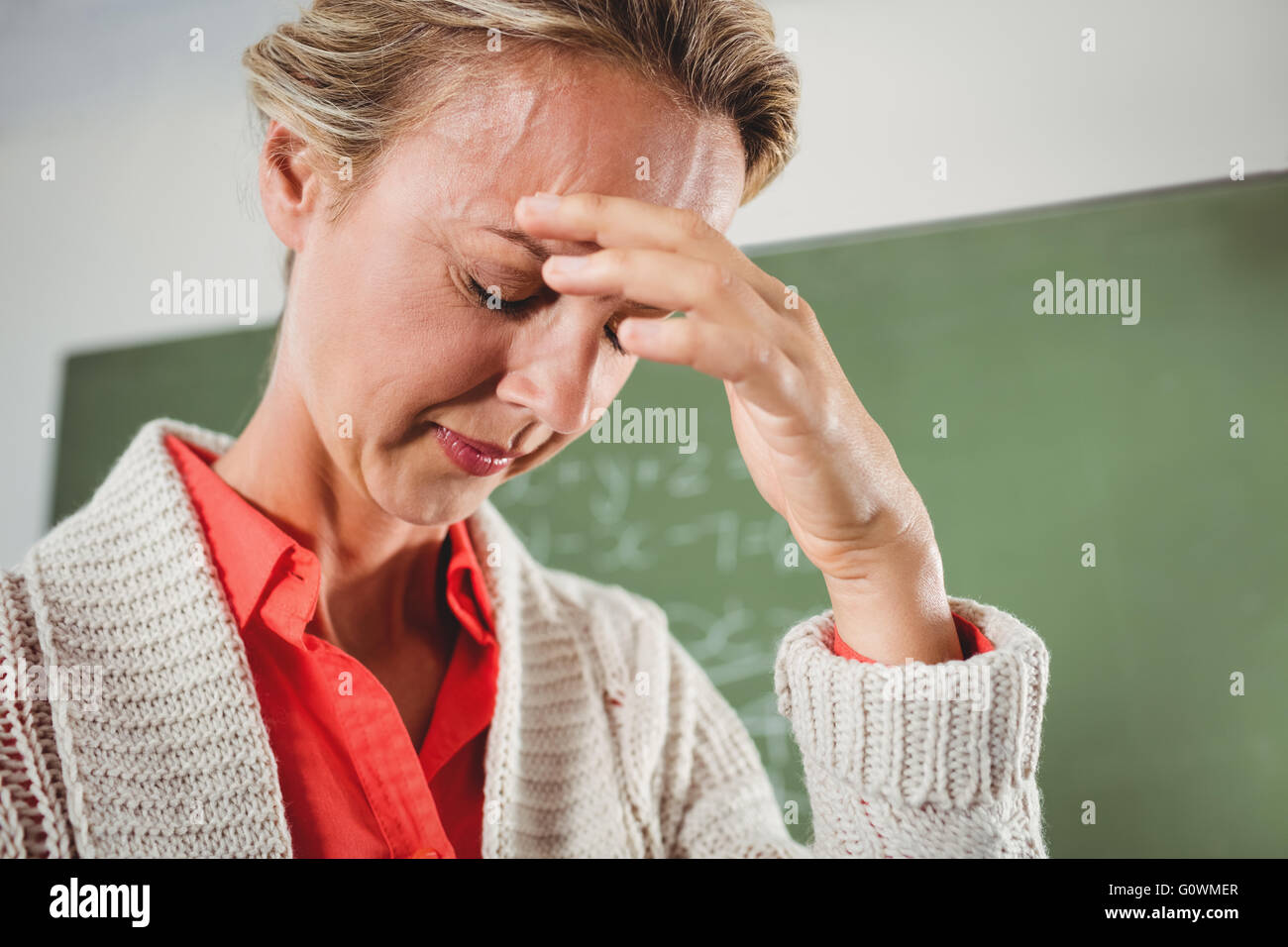 Sad teacher in front of blackboard Stock Photo