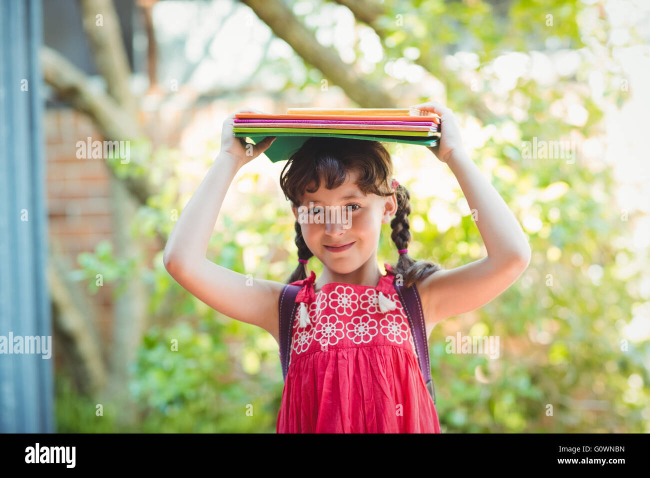 Girl holding books on her heads Stock Photo