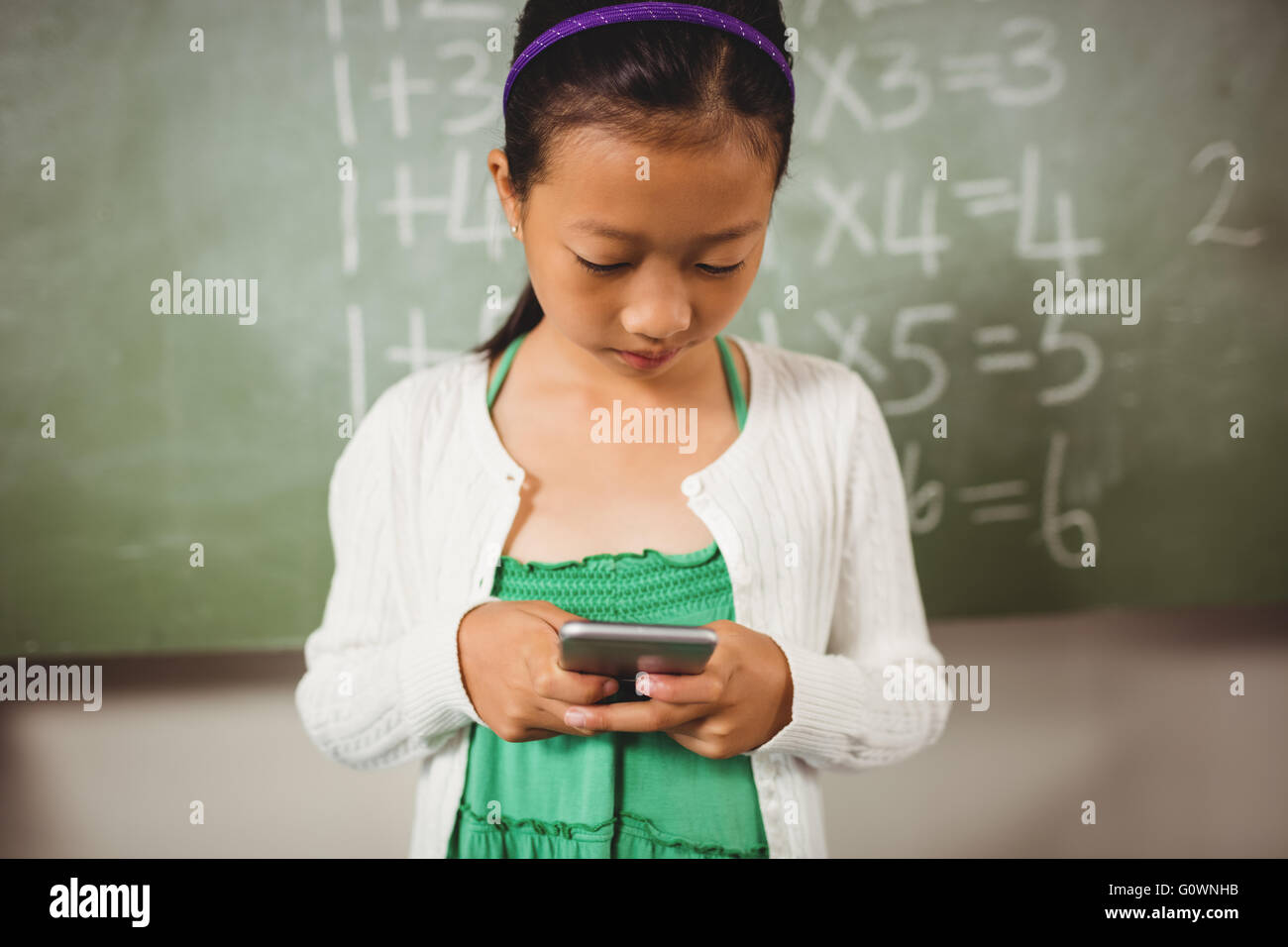 Schoolgirl using her smartphone Stock Photo