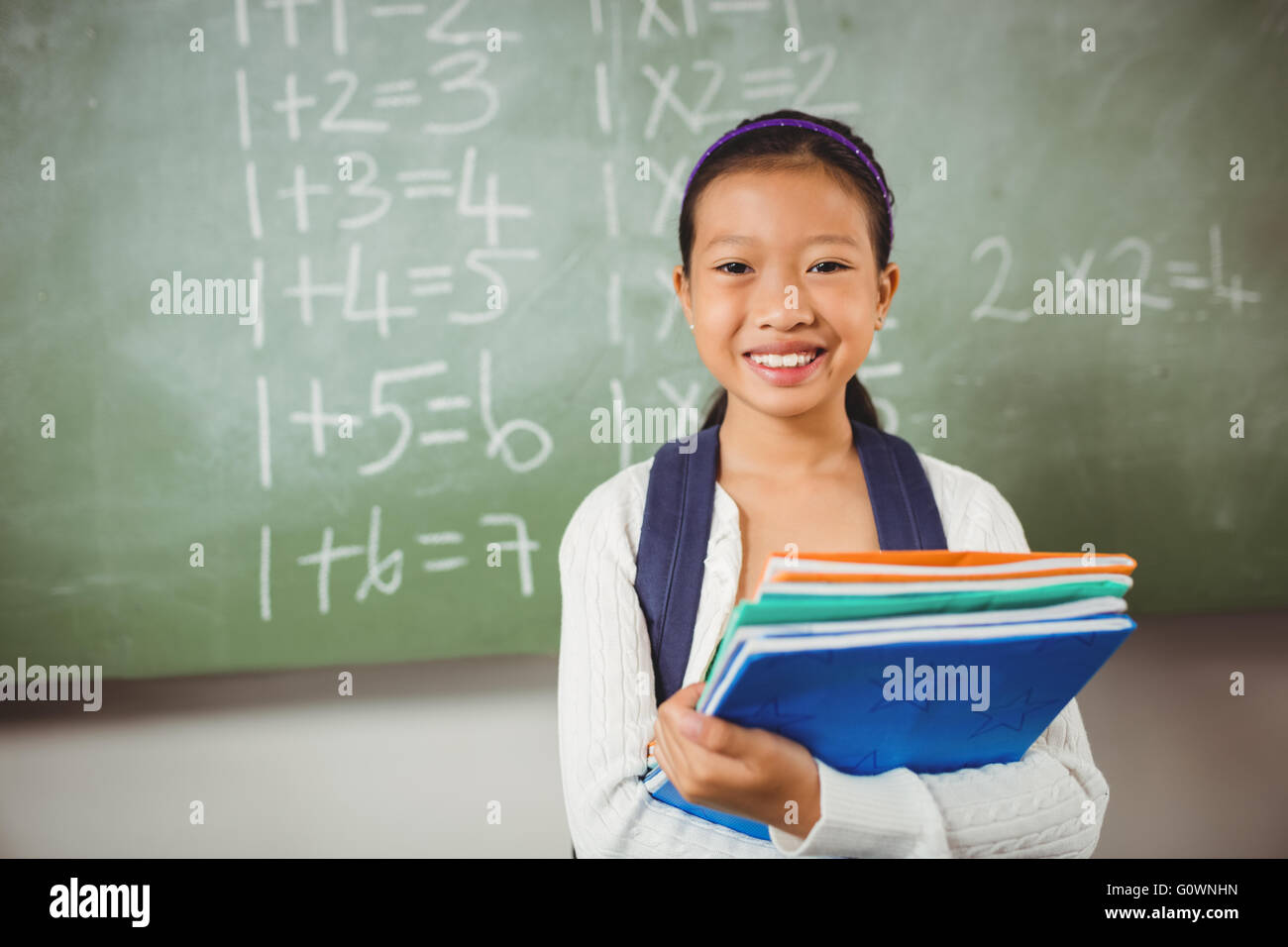 Smiling schoolgirl holding books Stock Photo - Alamy