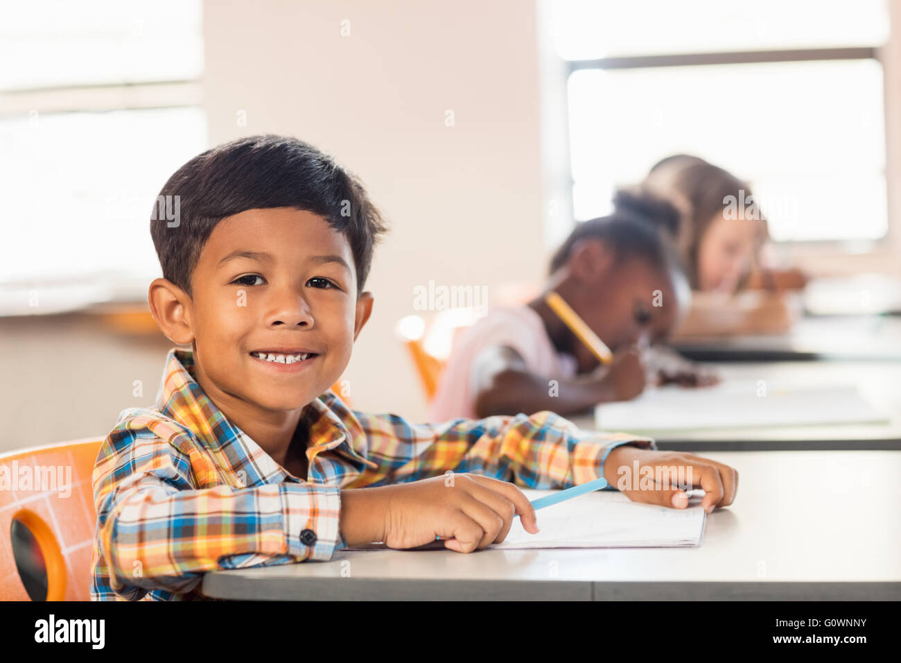 A cute pupil posing at his desk Stock Photo - Alamy