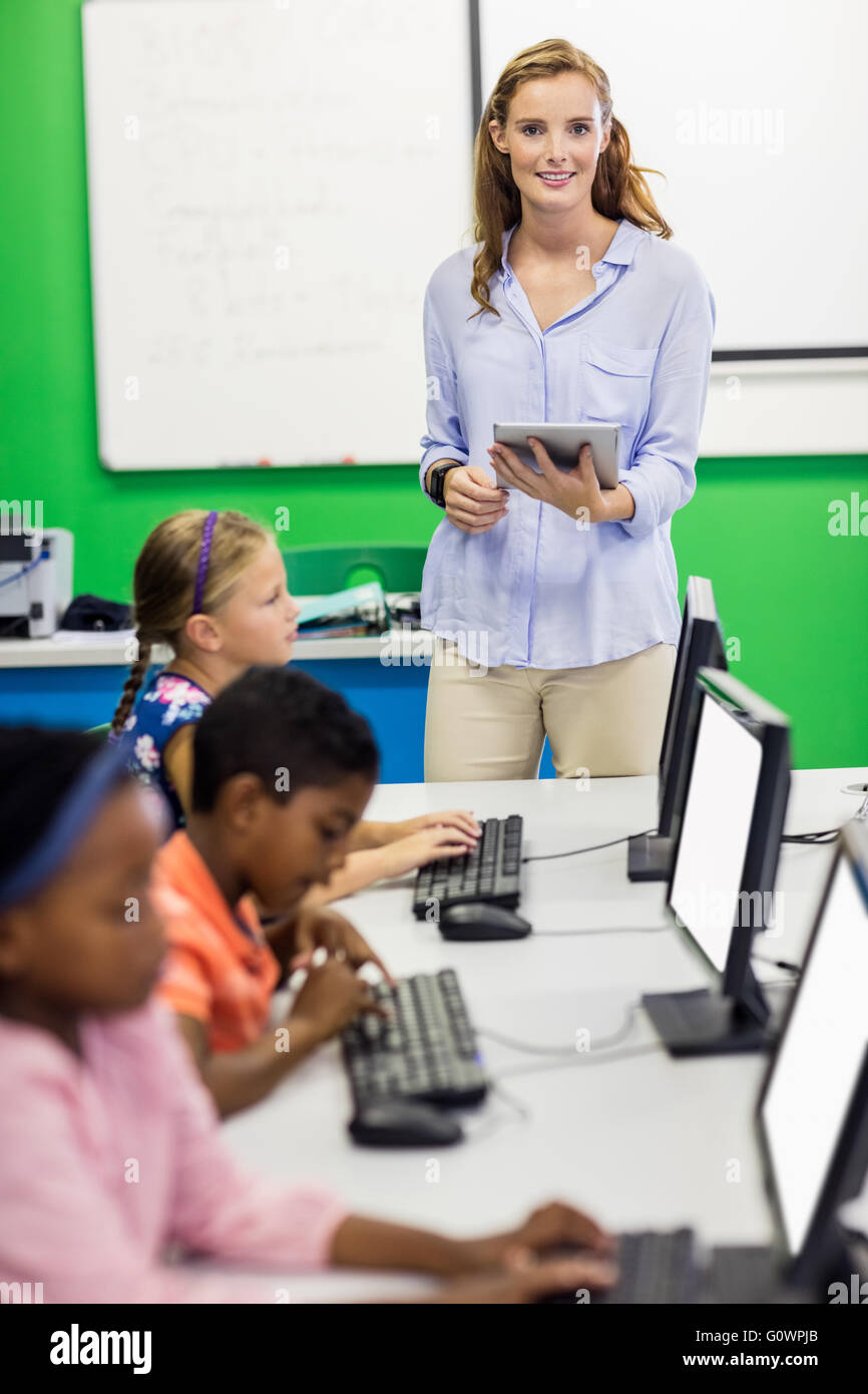 Teacher giving lesson to her students with technology Stock Photo - Alamy