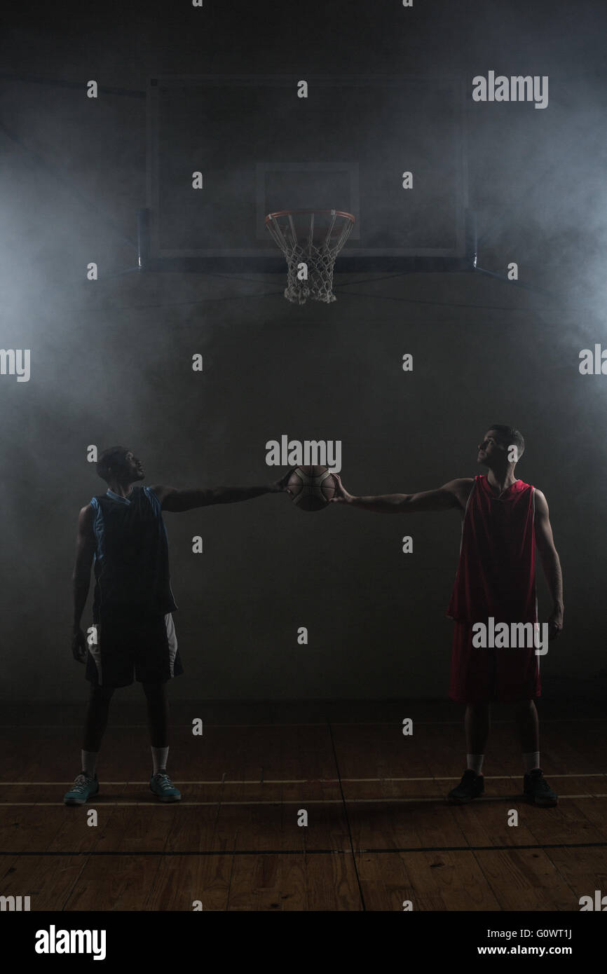 Two basketball player holding a single basketball Stock Photo