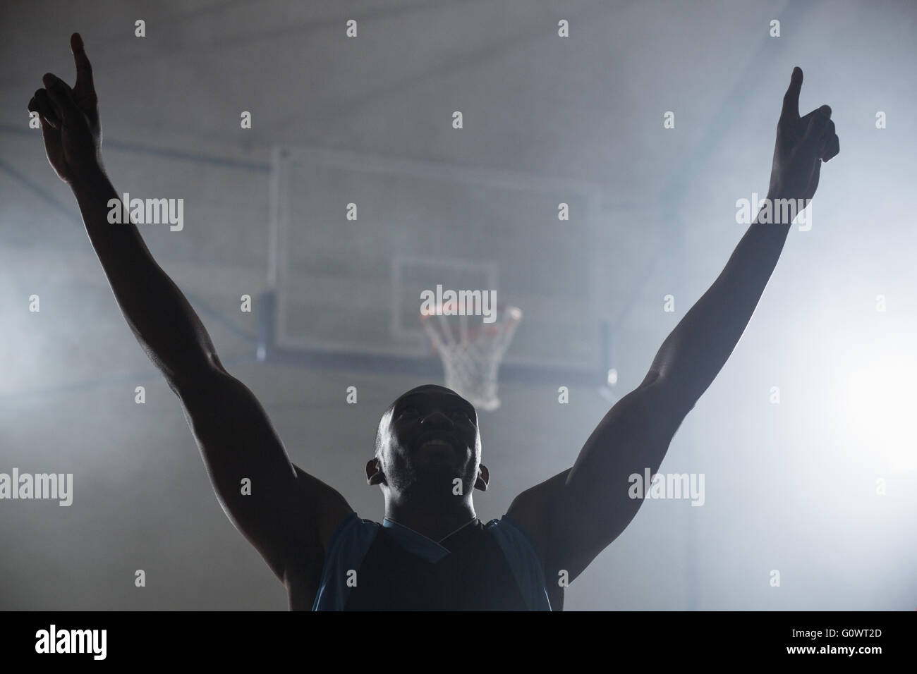 Rear view of a basketball player with his arms in the air Stock Photo