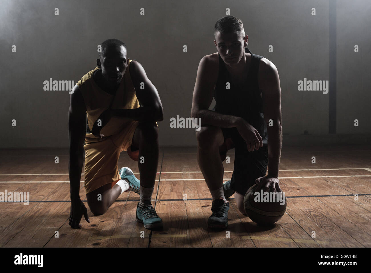 Portrait basketball players posing on their knees Stock Photo
