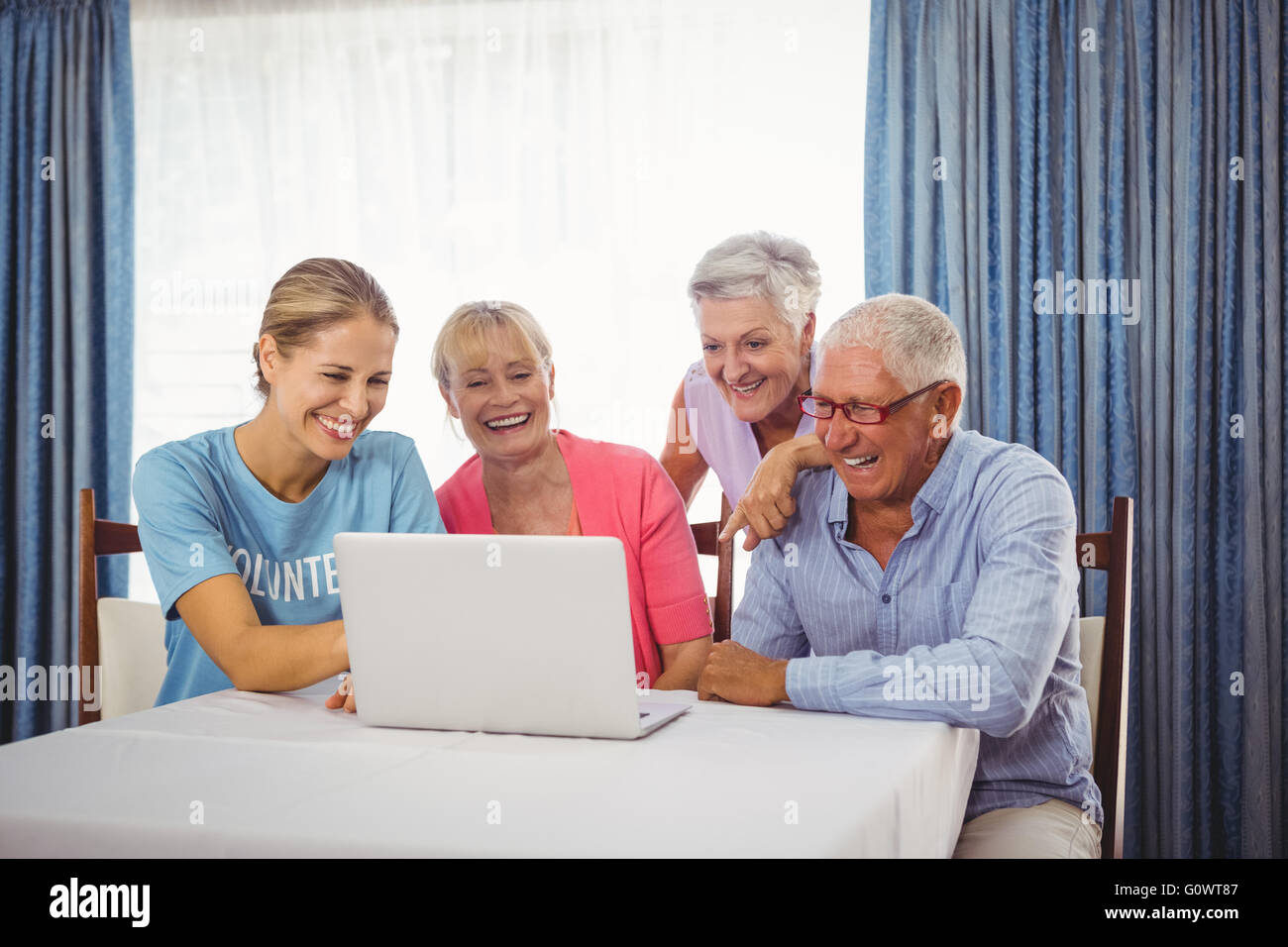 Seniors and woman using laptop Stock Photo