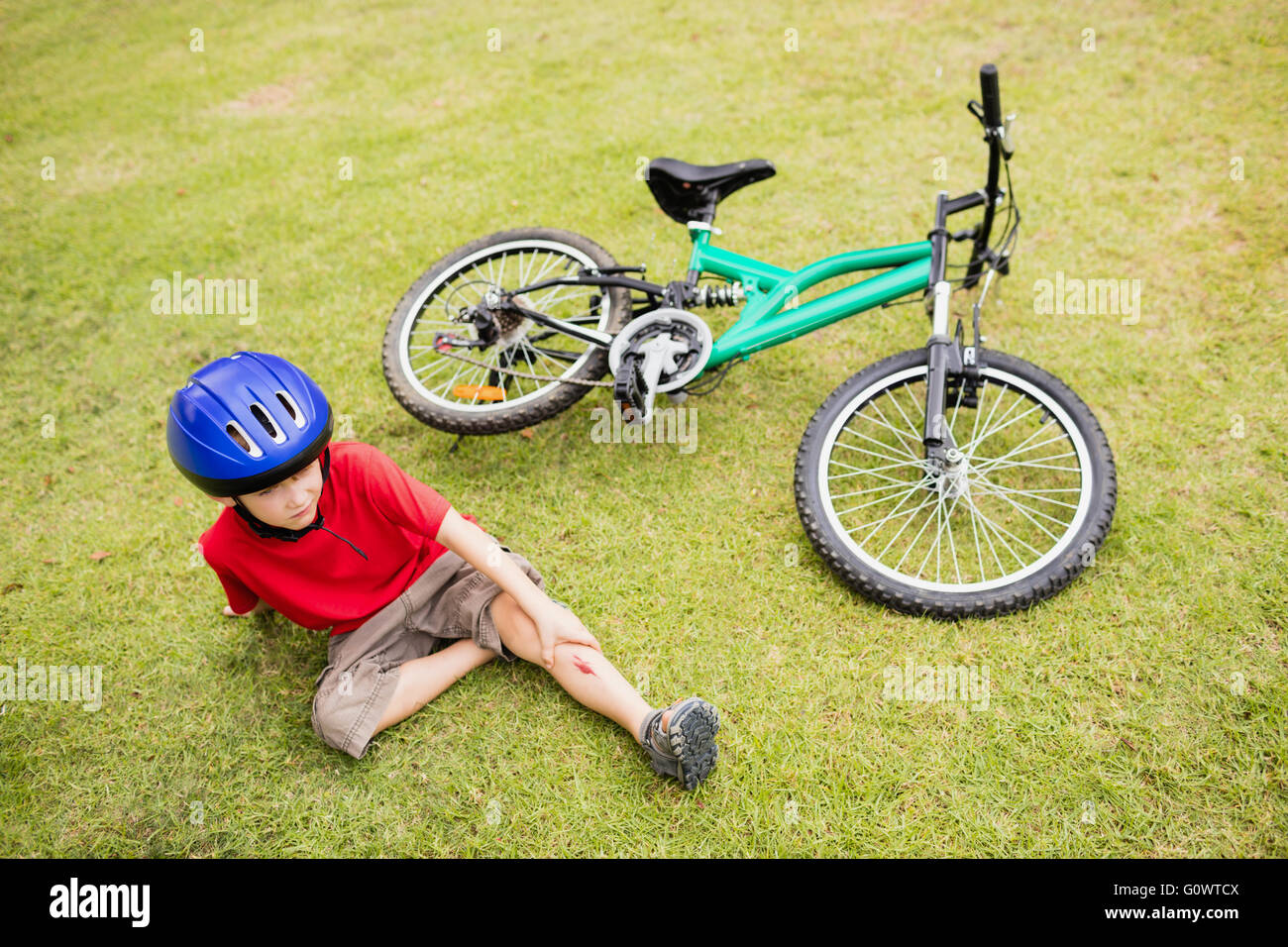 Sad child falling from his bike Stock Photo