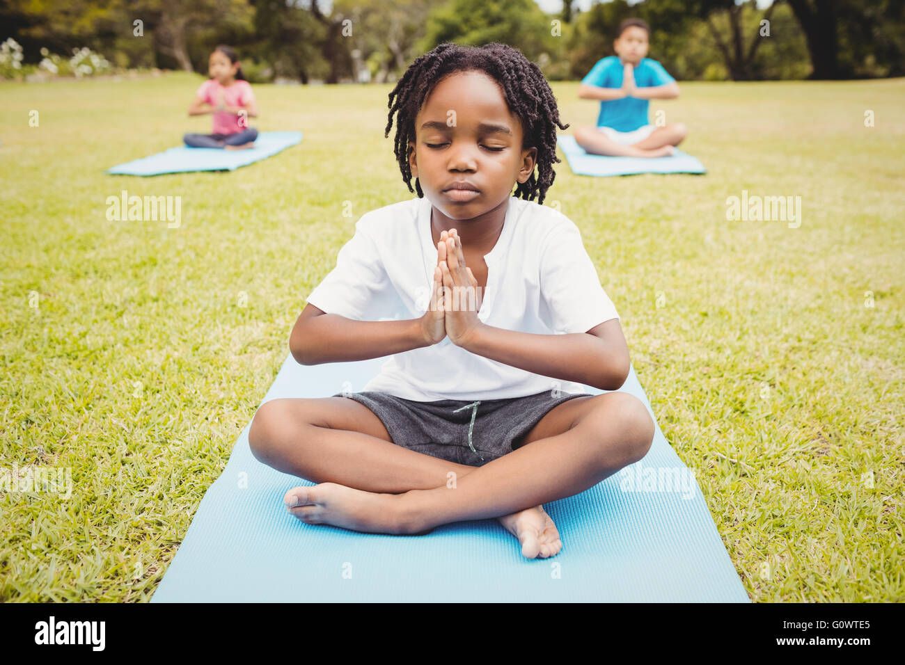 Portrait of child doing yoga with friends Stock Photo