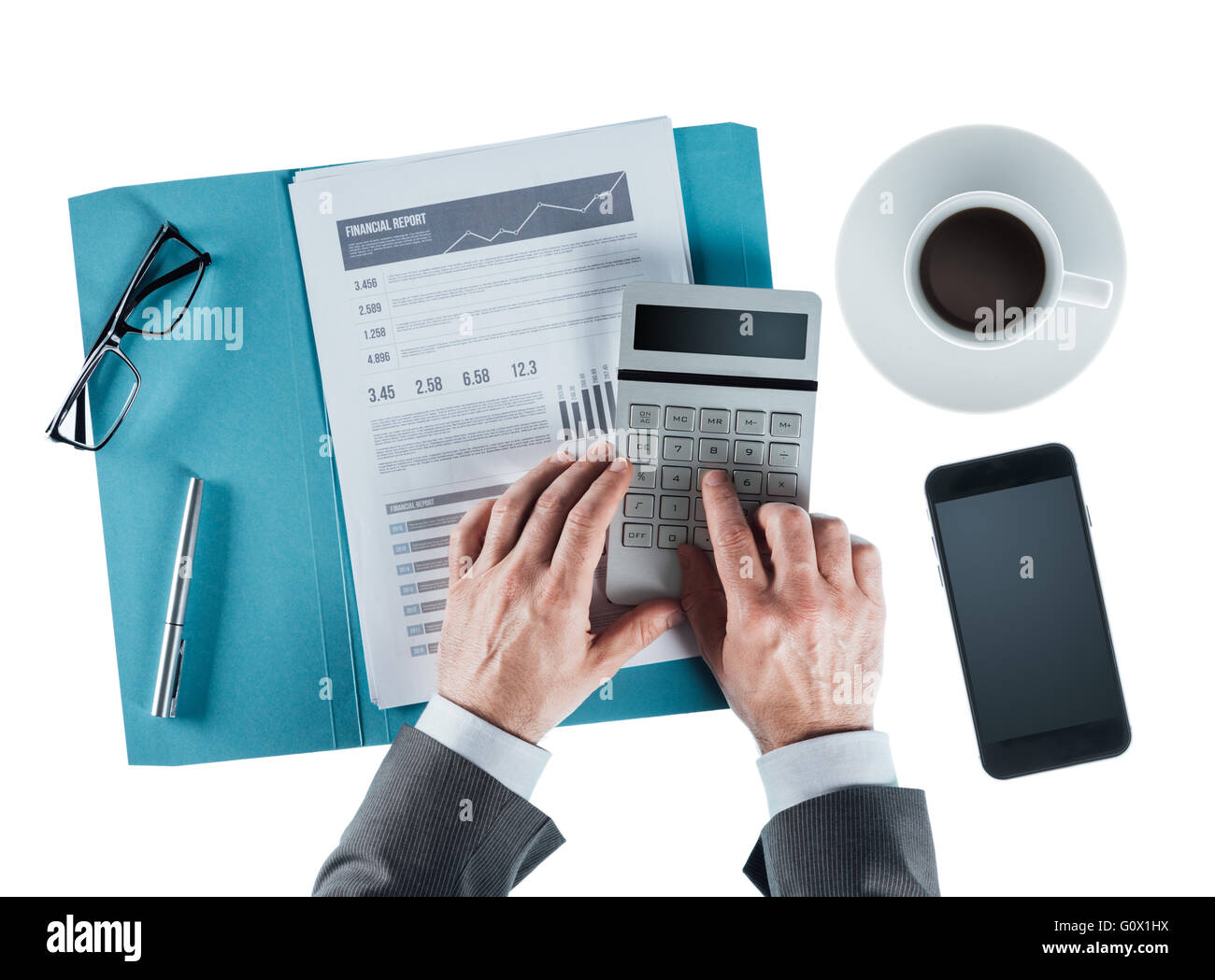 Professional businessman at desk checking a financial report and using a calculator Stock Photo