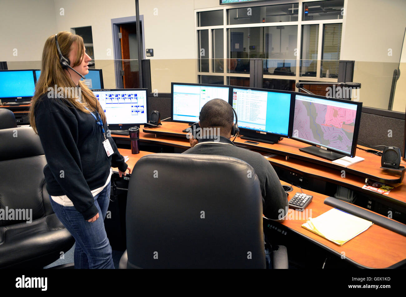 A Prince George's County  fire  department dispatcher(white female)is training a rookie dispatcher (black male) in Bowie, Maryla Stock Photo
