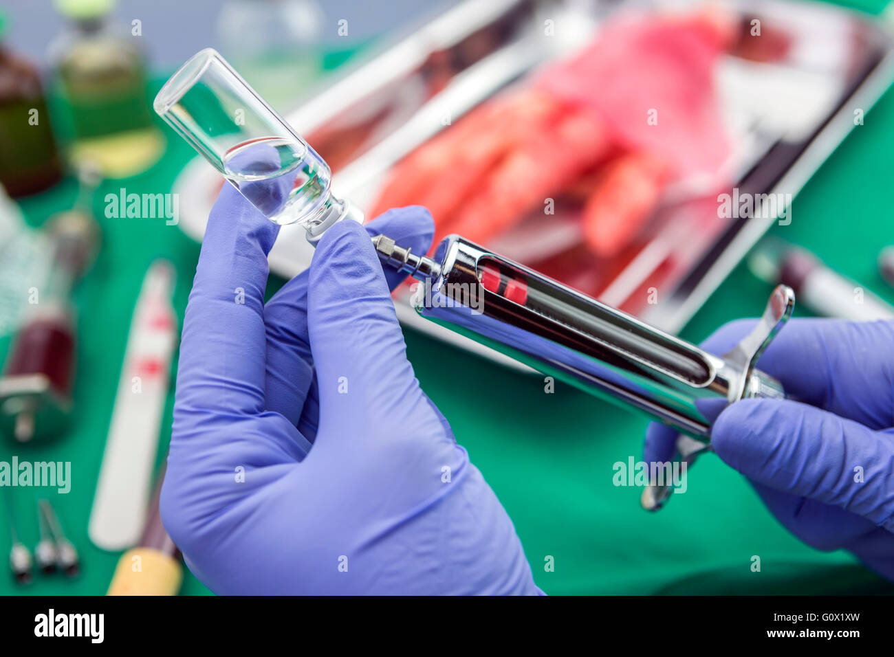 Nurse filling syringe with medication in a room of operating theater