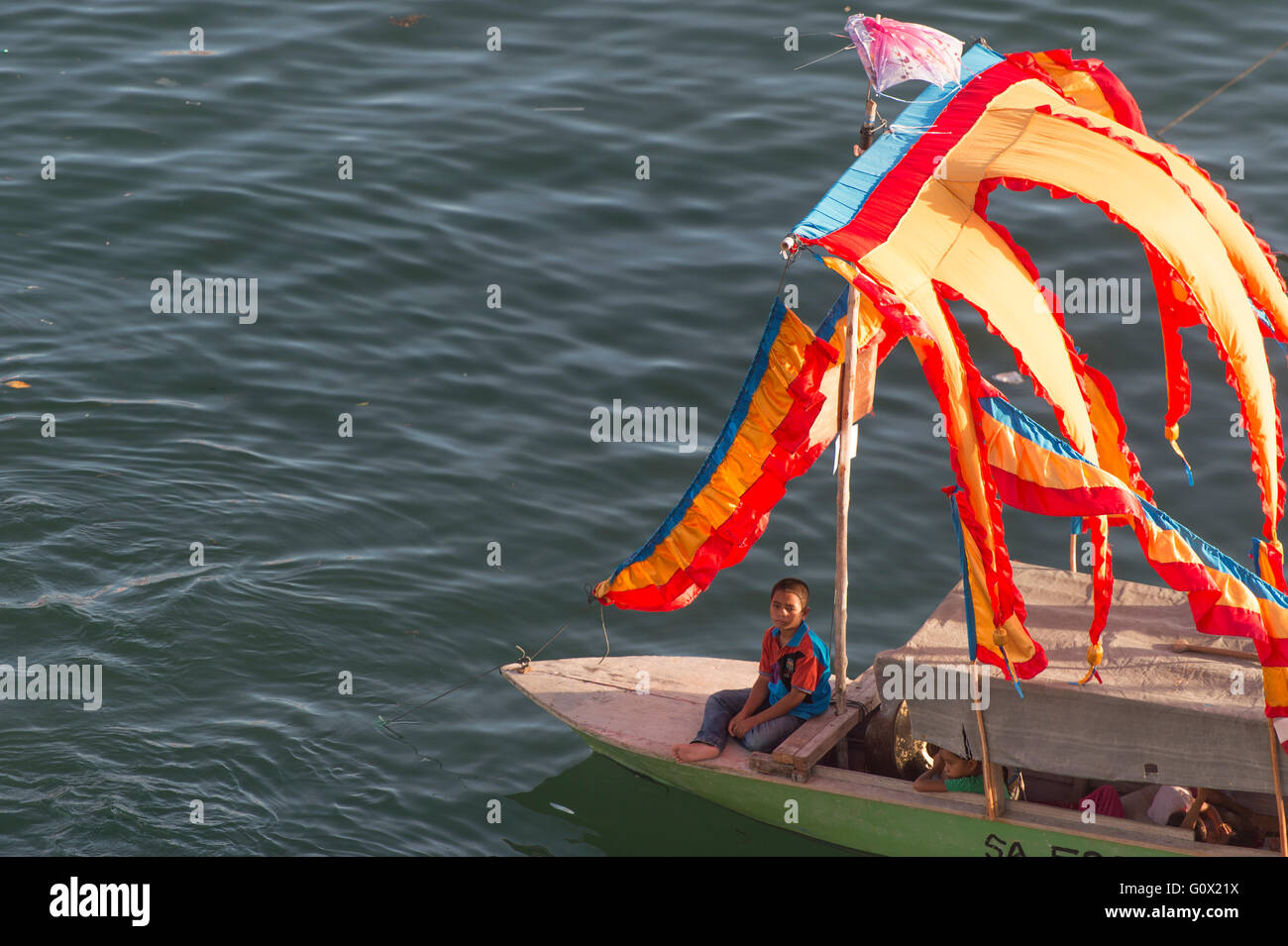 Young boy sitting infront the Traditional Bajau's boat called Lepa Lepa Stock Photo