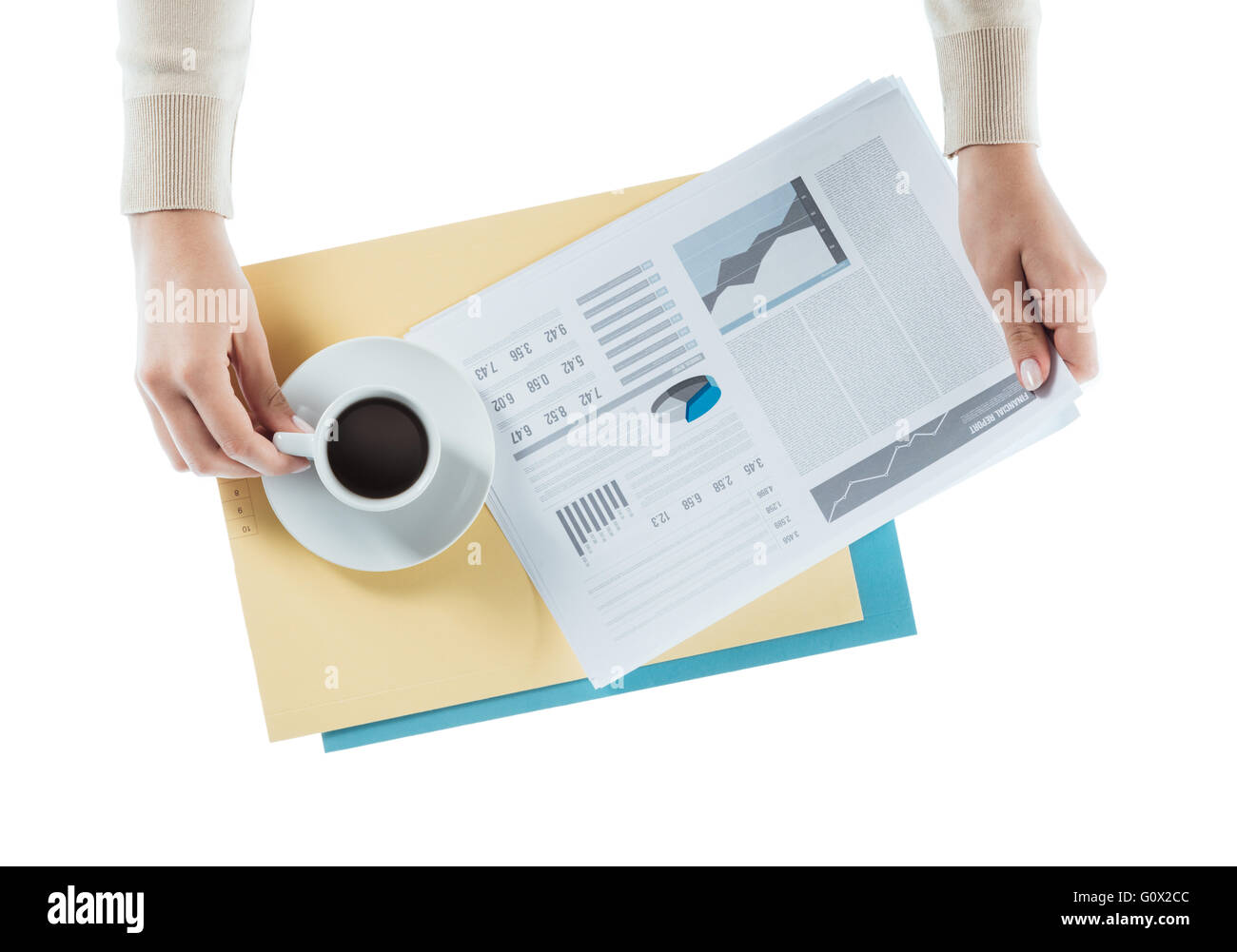 Business woman having a coffee at office desk while reading a financial report, hands close up Stock Photo