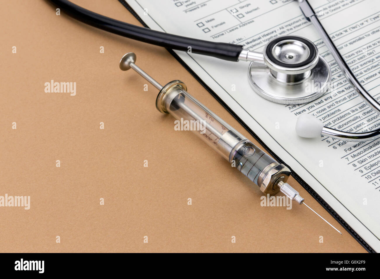 Test medication and stethoscope, Old Syringe isolated on brown background Stock Photo