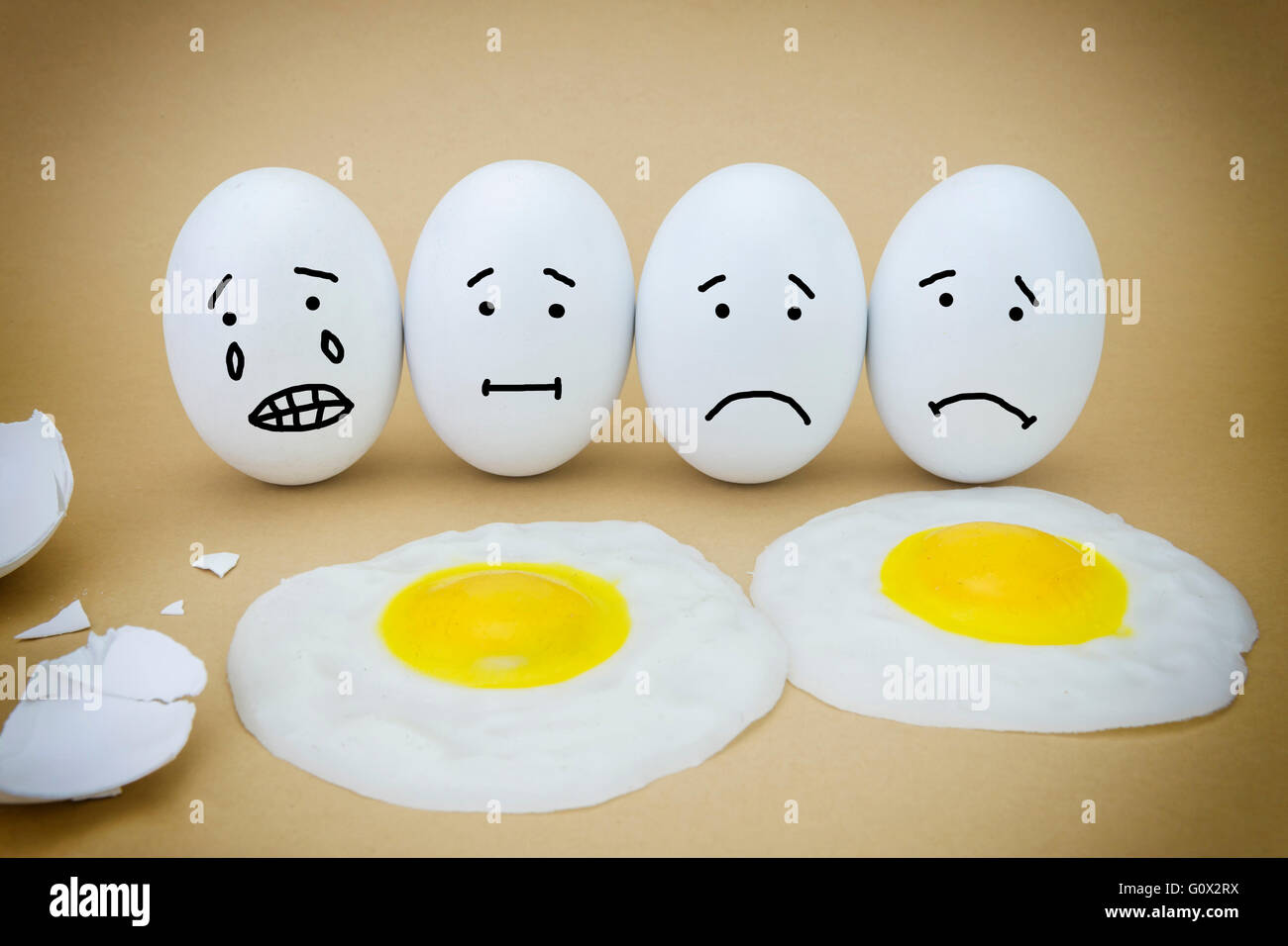 Funny emotional eggs crying and laughing in the box with yolk Stock Photo