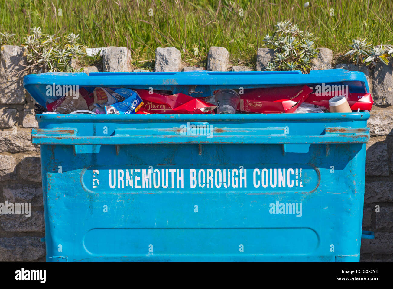 Bournemouth Borough Council rubbish bin full of rubbish on promenade at