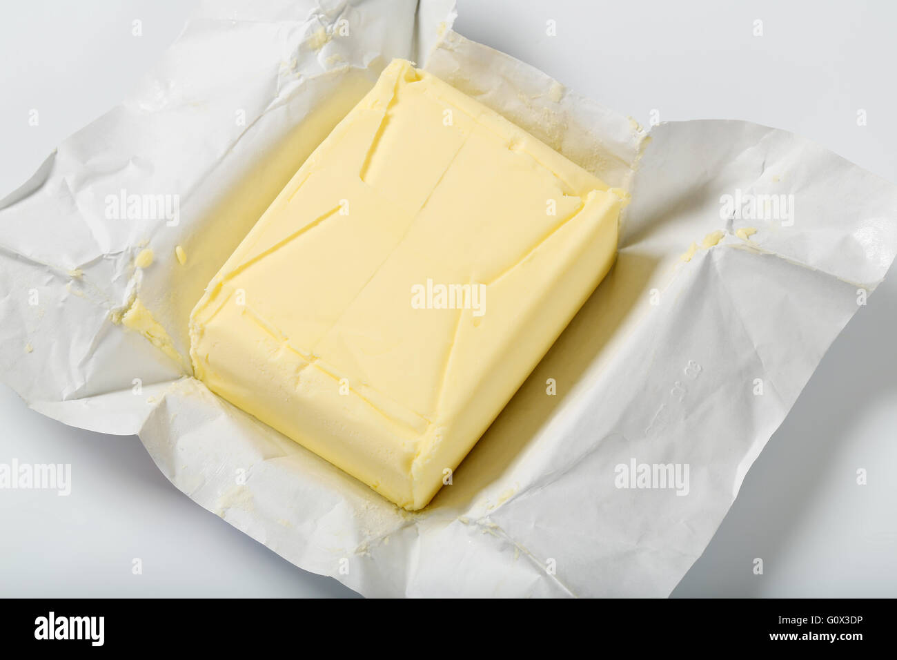 block of fresh butter on white background - close up Stock Photo