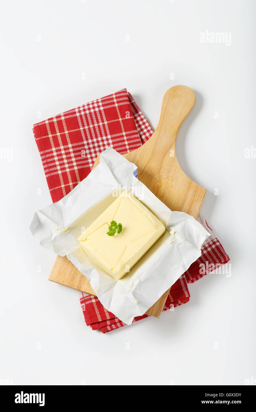block of fresh butter on wooden cutting board Stock Photo